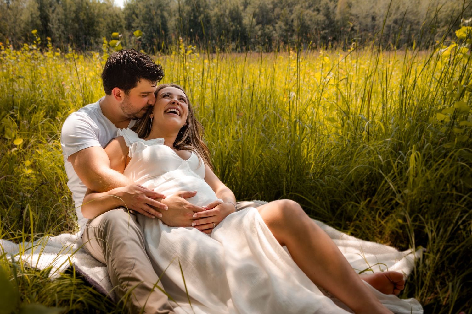 maternity photo, mom and dad on blanket in a field