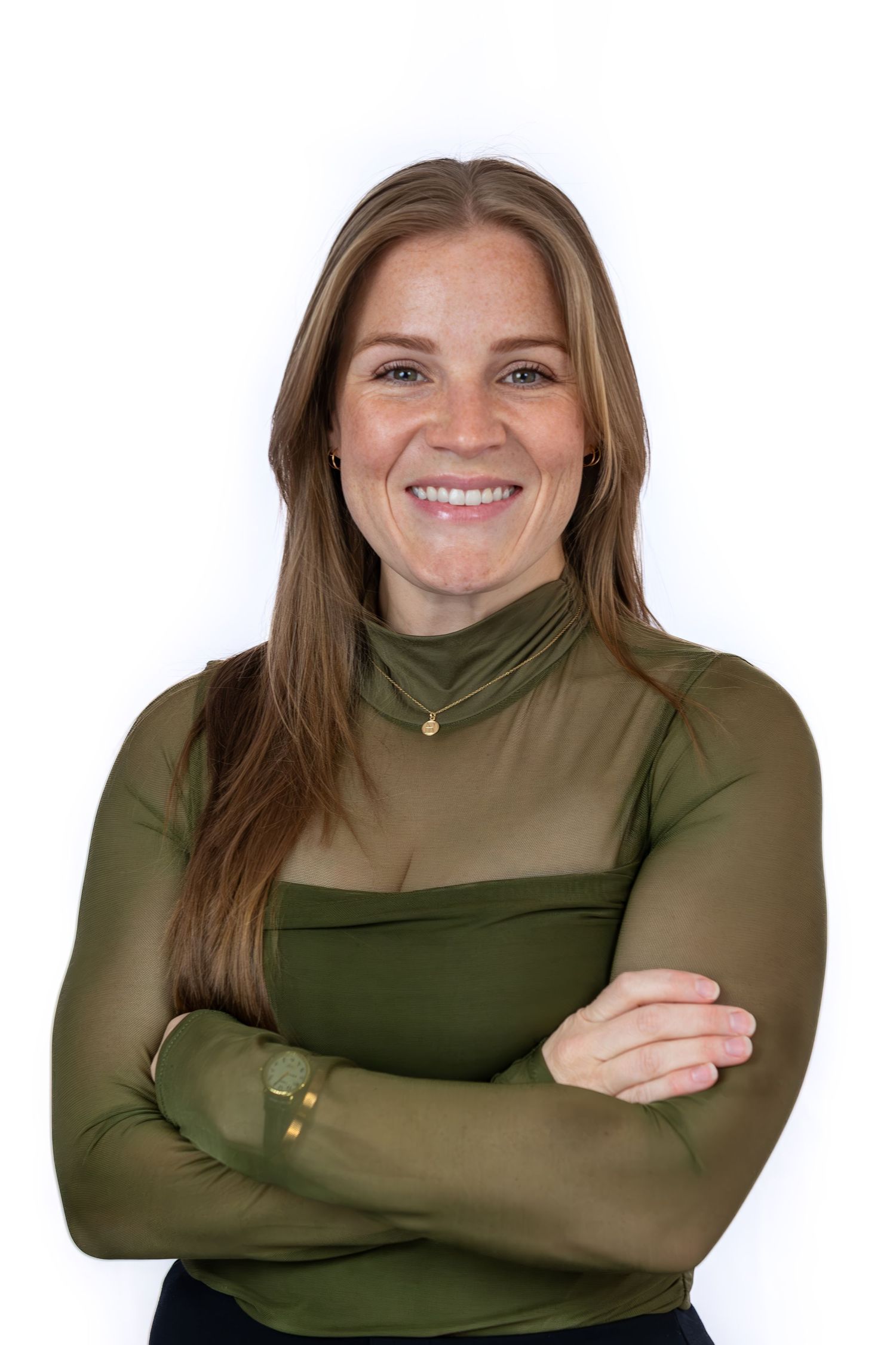 Smiling woman with long brown hair, freckles, arms crossed, wearing an olive green turtleneck top against white background.