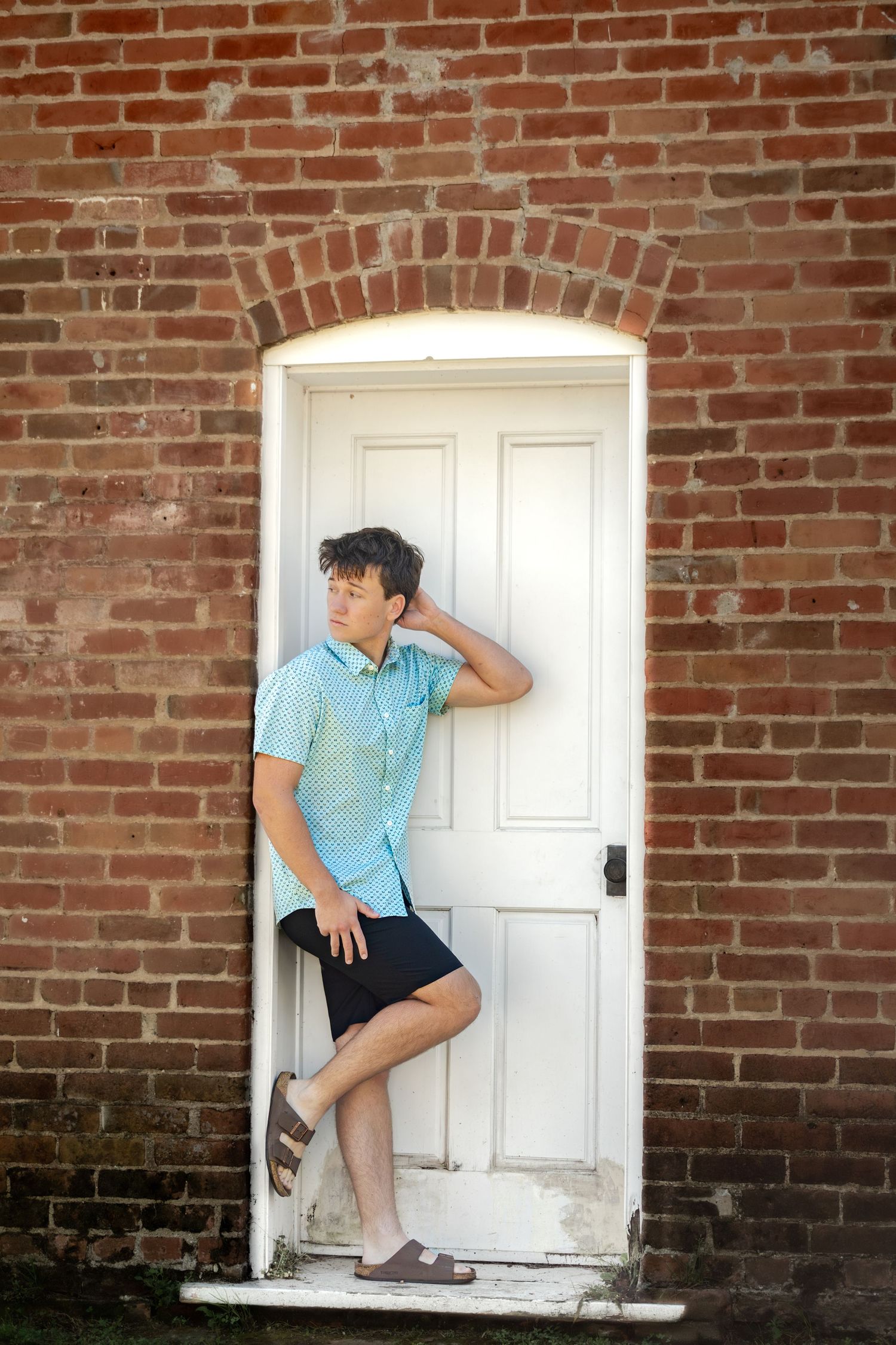 Creative poses against a vintage brick wall with white door.