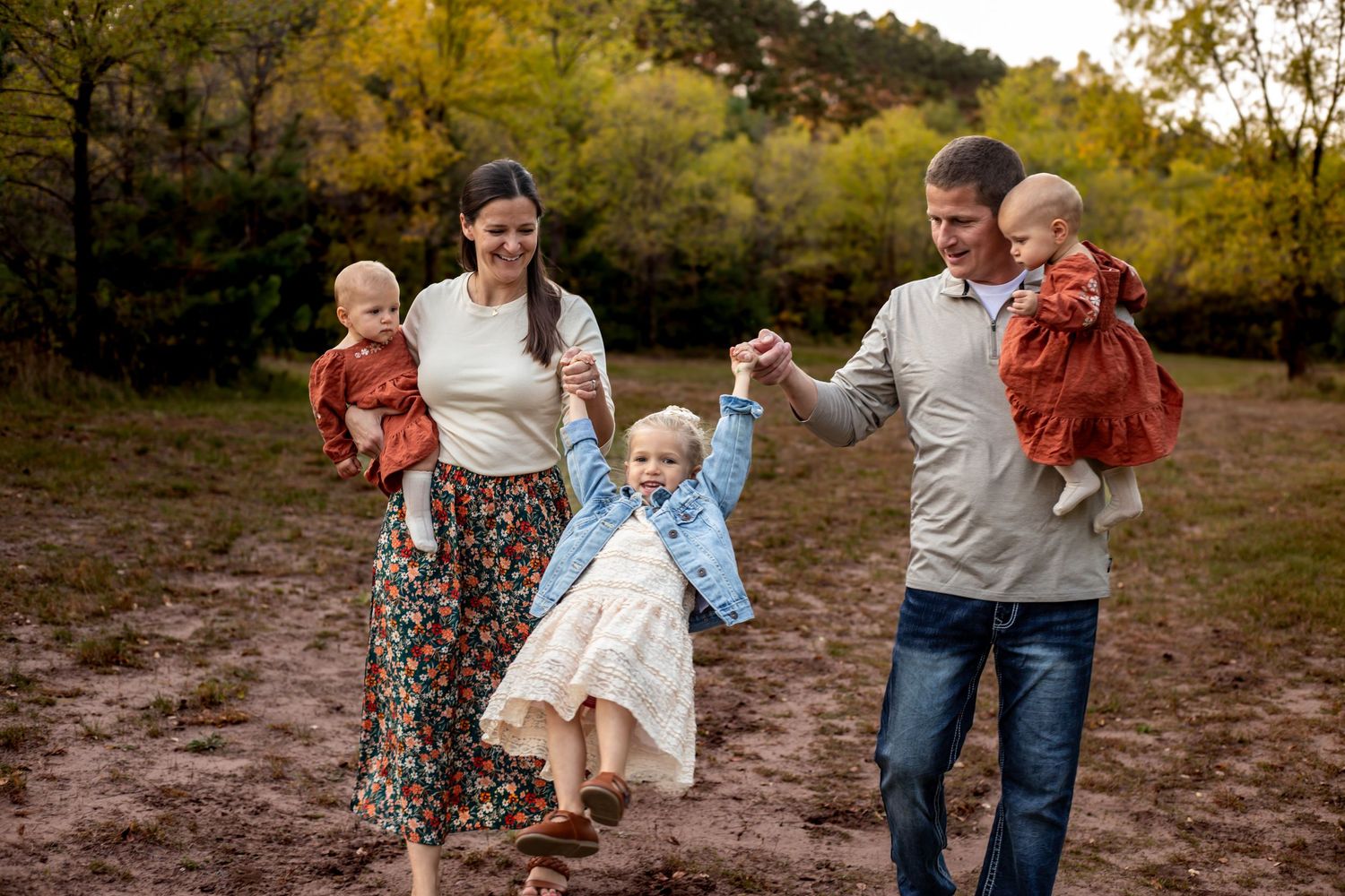 lifestyle-photography-family-swinging-daughter-walking-with-trees-in-background.jpg