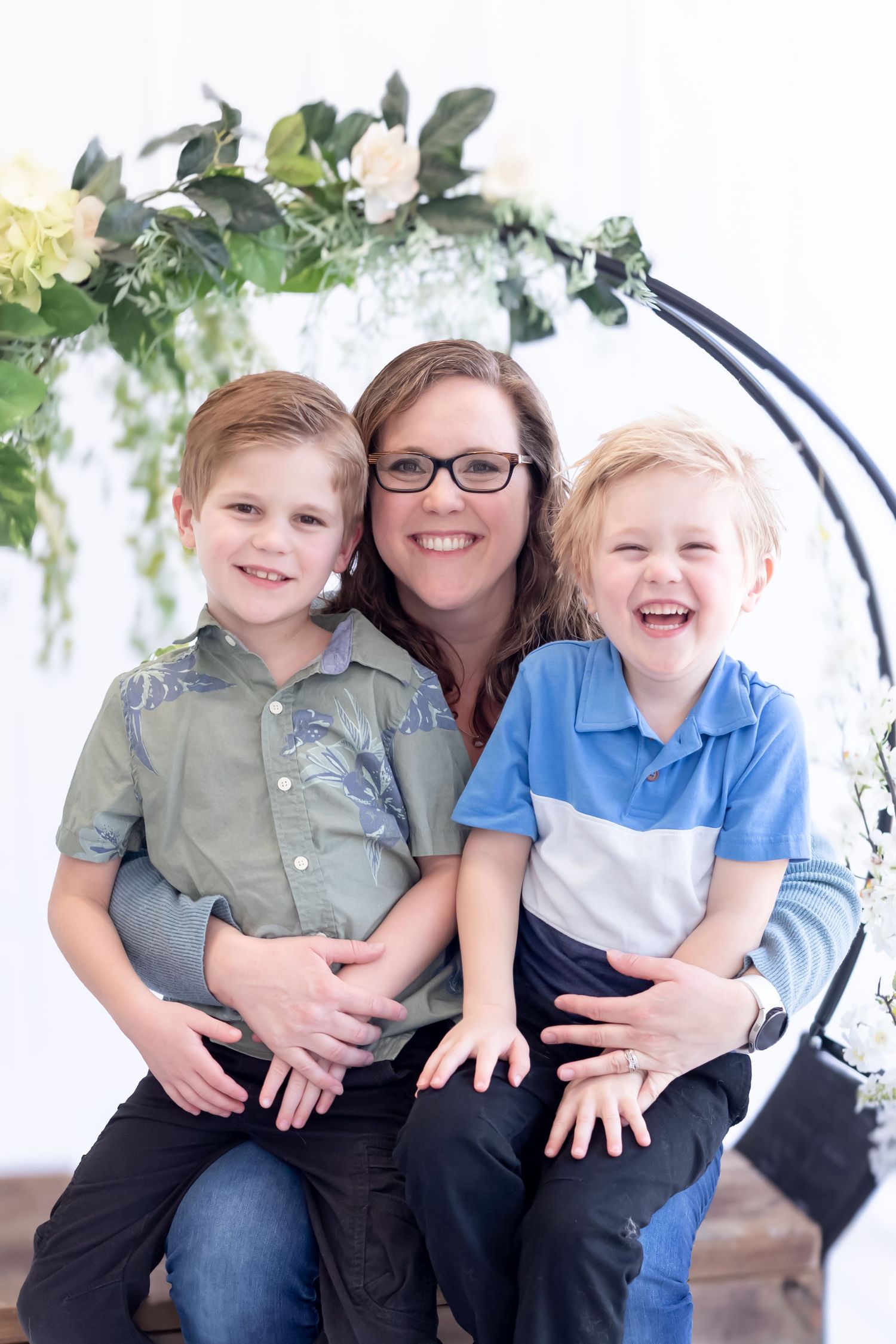 A series of candid family photos showing joyful moments together on a white backdrop with green foliage accents.