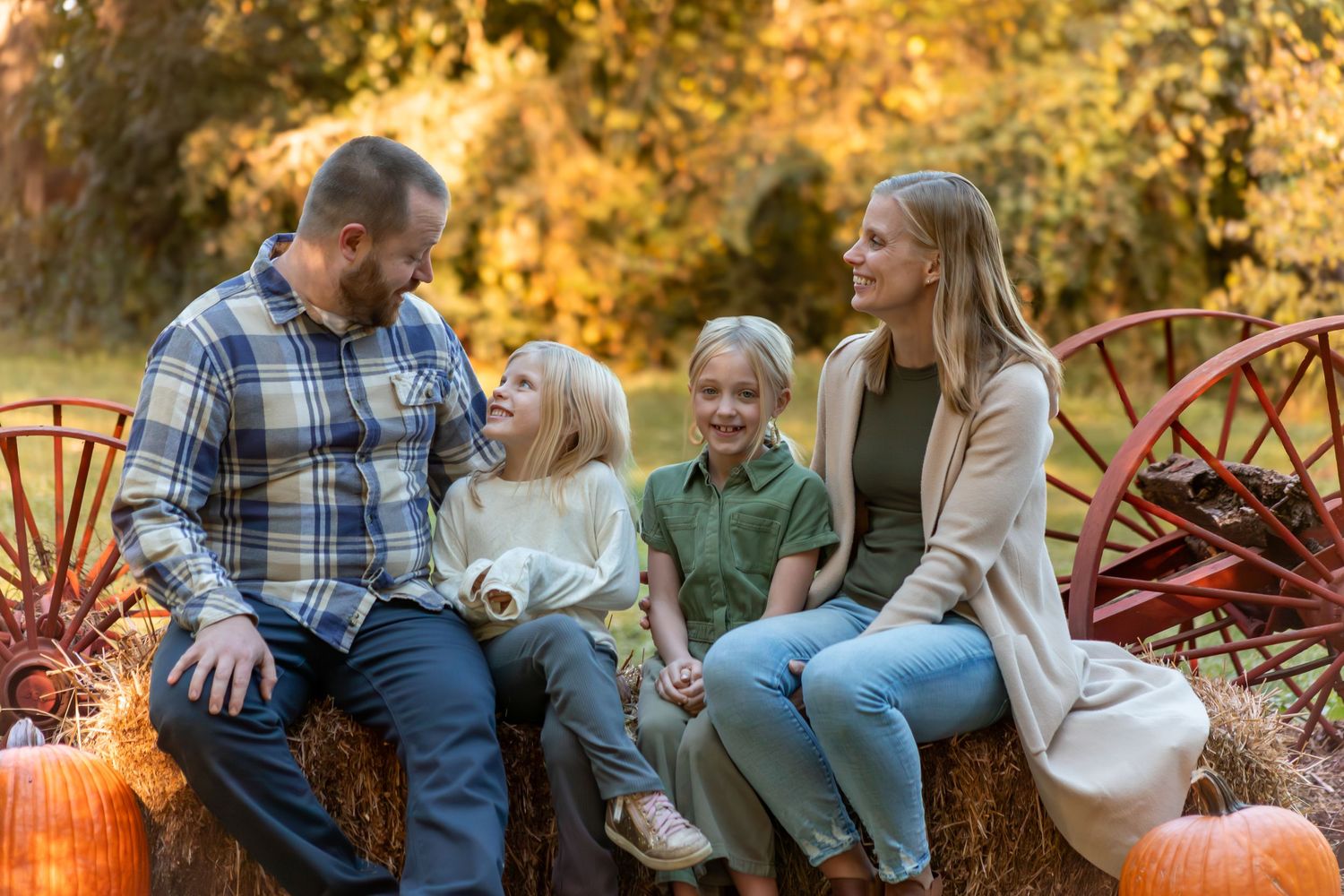 Candid family portrait session outdoors with fall foliage in the background.