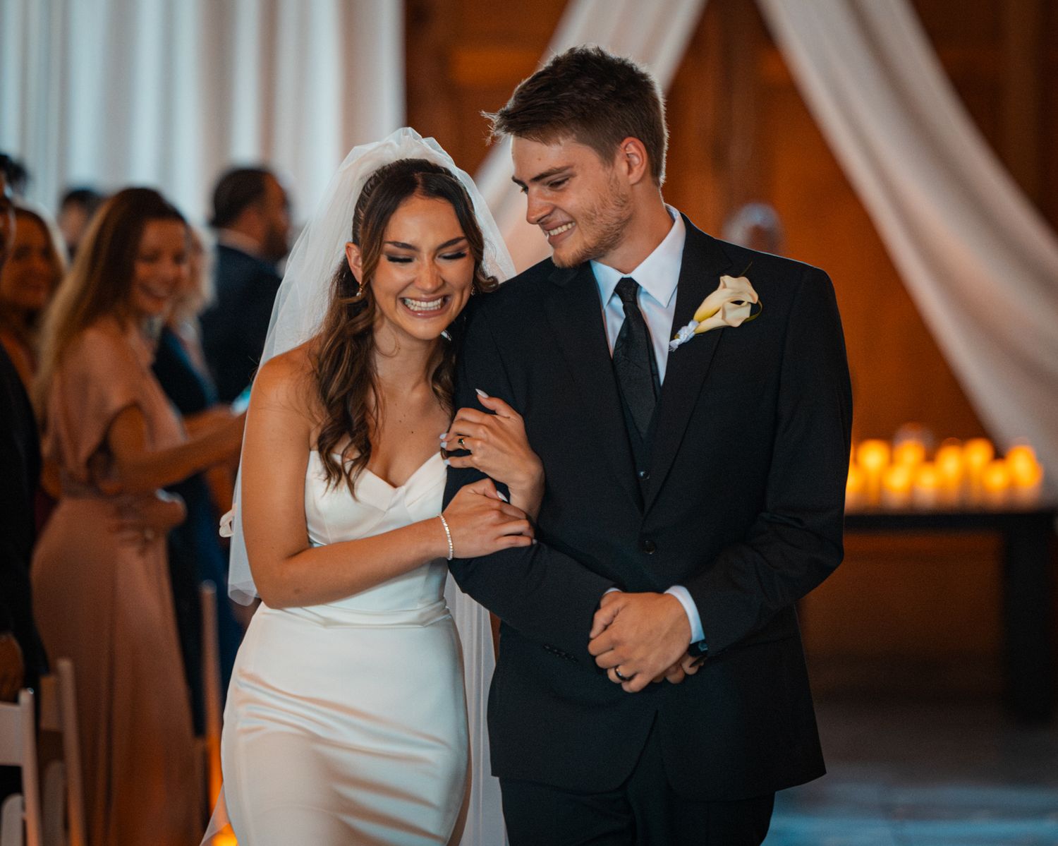 Wedding couple sharing intimate moments on their special day in a warmly lit venue.