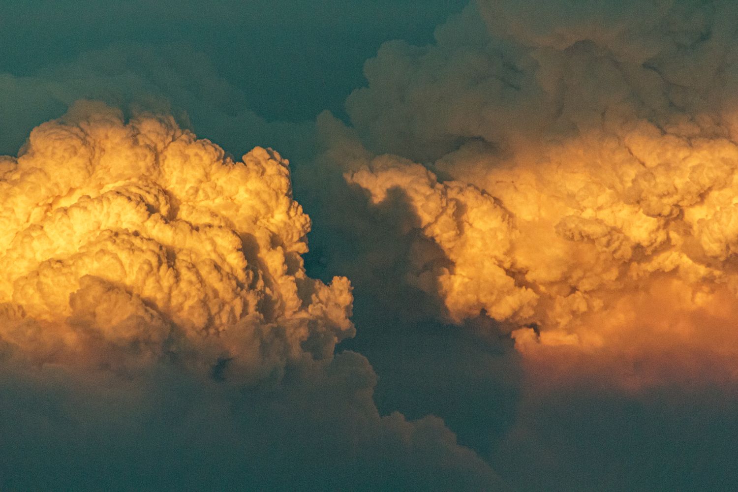 Stunning panorama of golden clouds at sunset with turquoise sky.