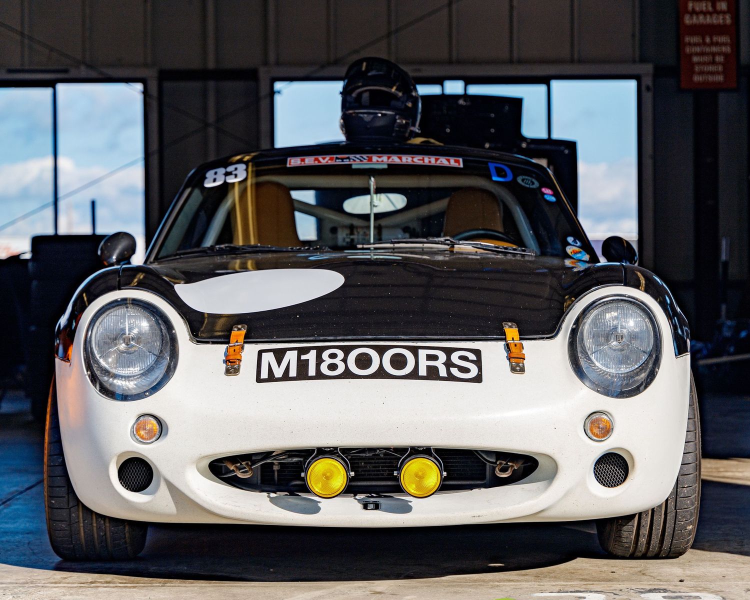 Front view of a customized white classic car with racing modifications and M1800RS badging.