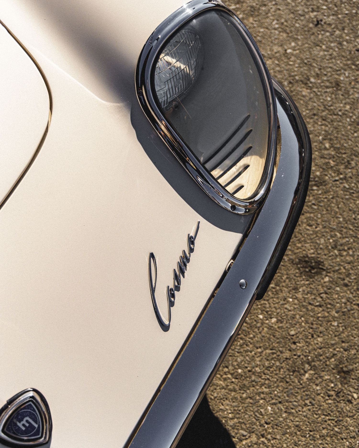Close-up views of a classic white car's headlight assembly and front end design elements.