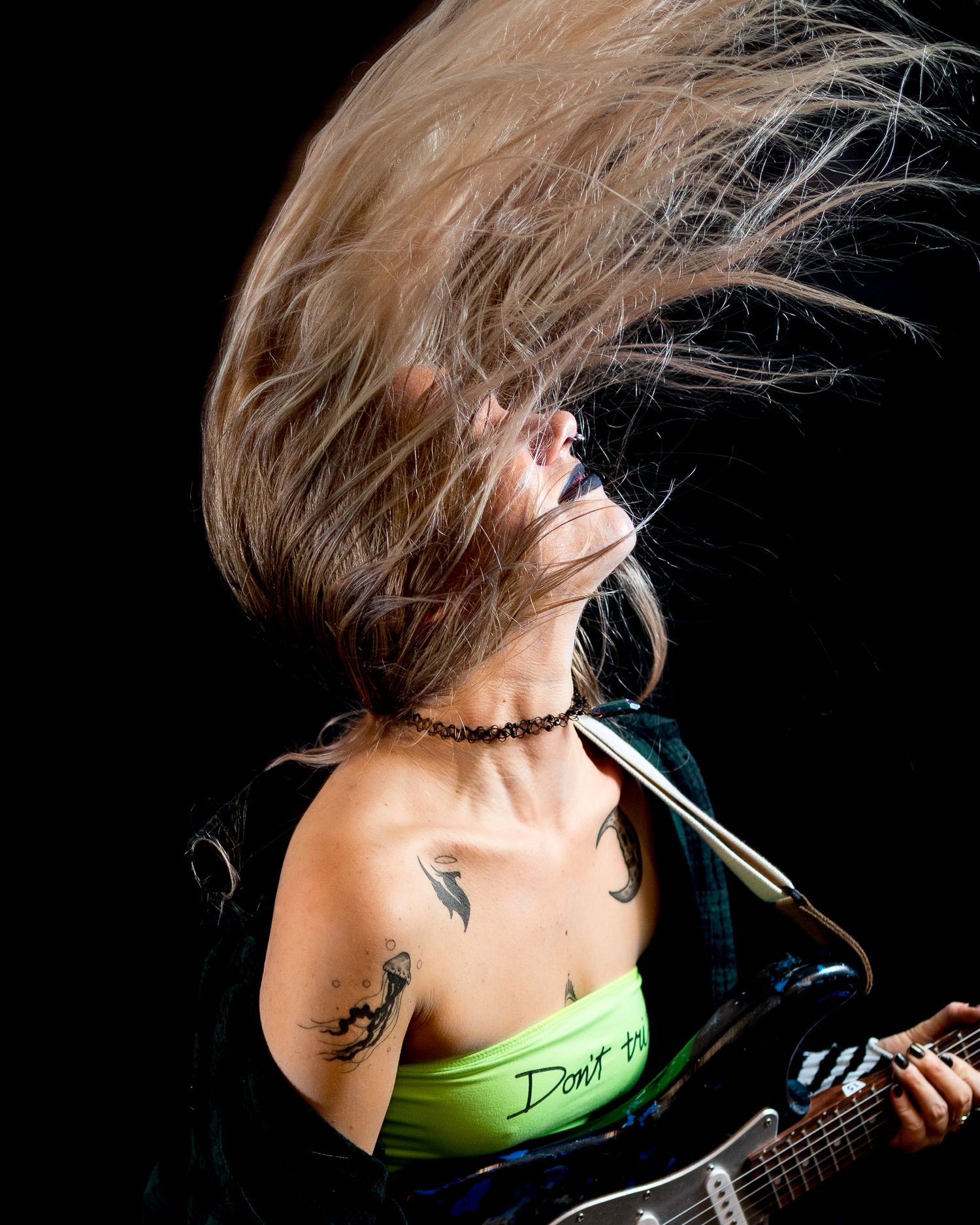 Dynamic hair flip photography sequence with guitar against dark background.