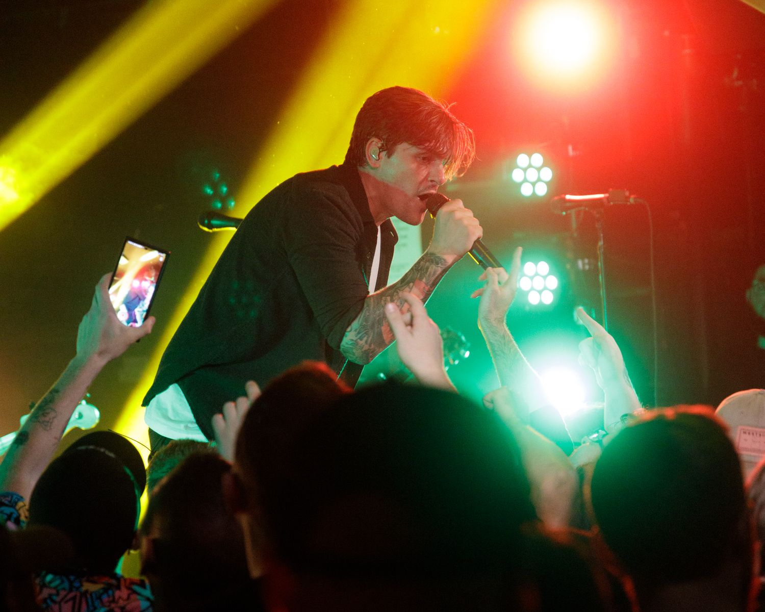 Concert stage lit with dramatic yellow and red lighting creating dynamic performance atmosphere.