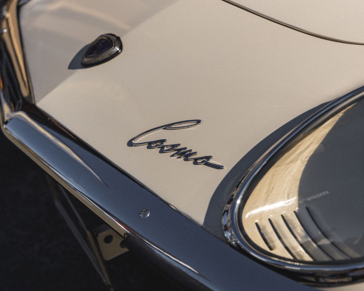 Detail shots of a white vintage car's curved body panels and chrome trim.