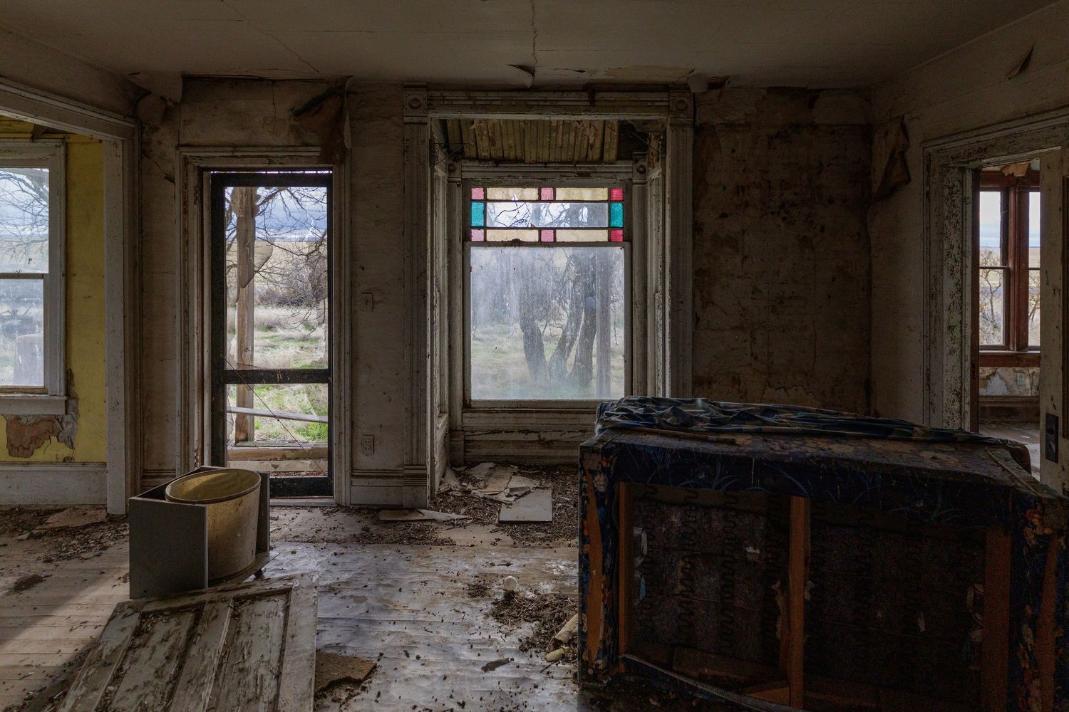 Interior panorama of a dilapidated building with broken windows and peeling walls.