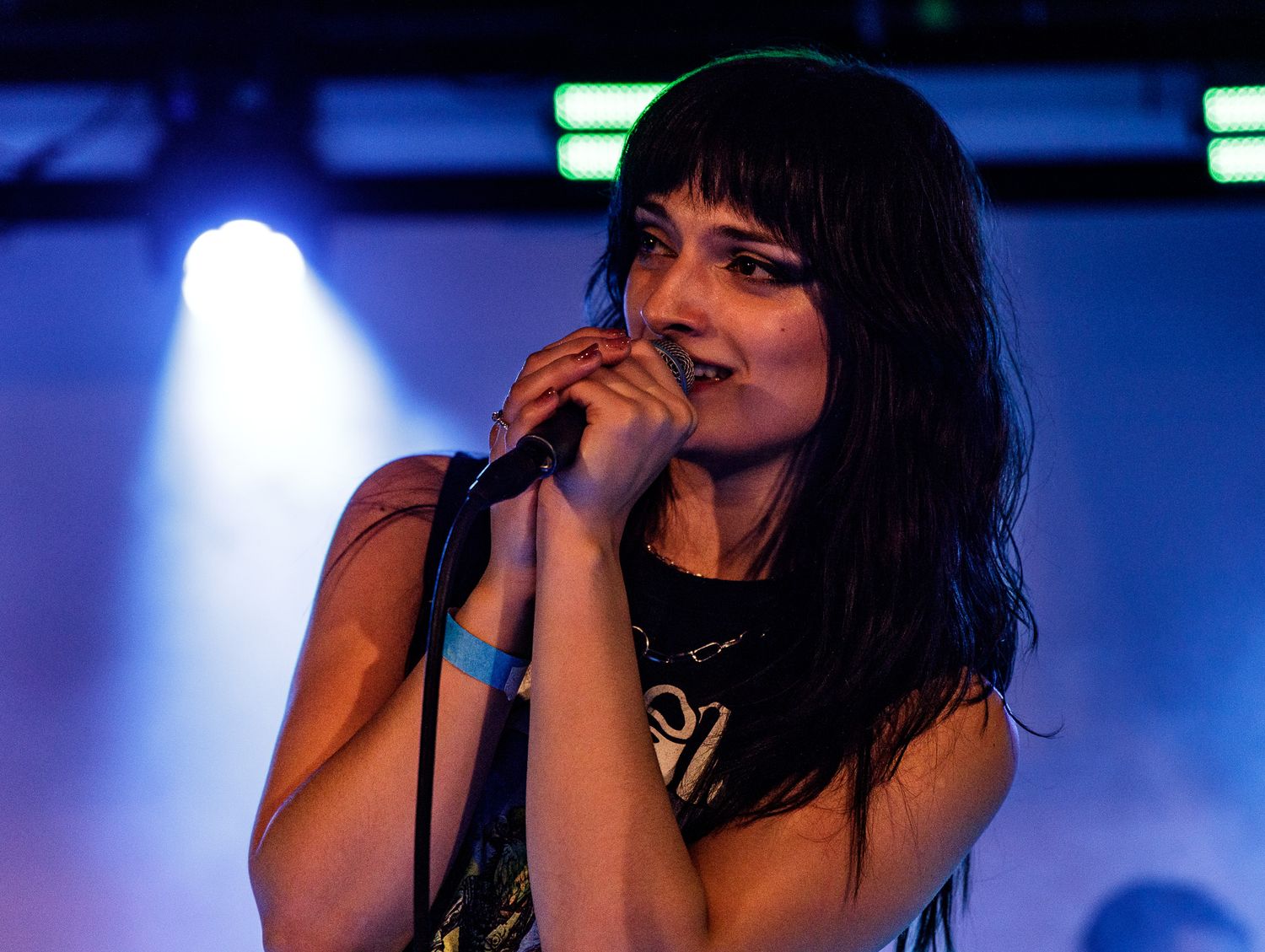 Dynamic stage performance captured in dramatic blue lighting at music venue.