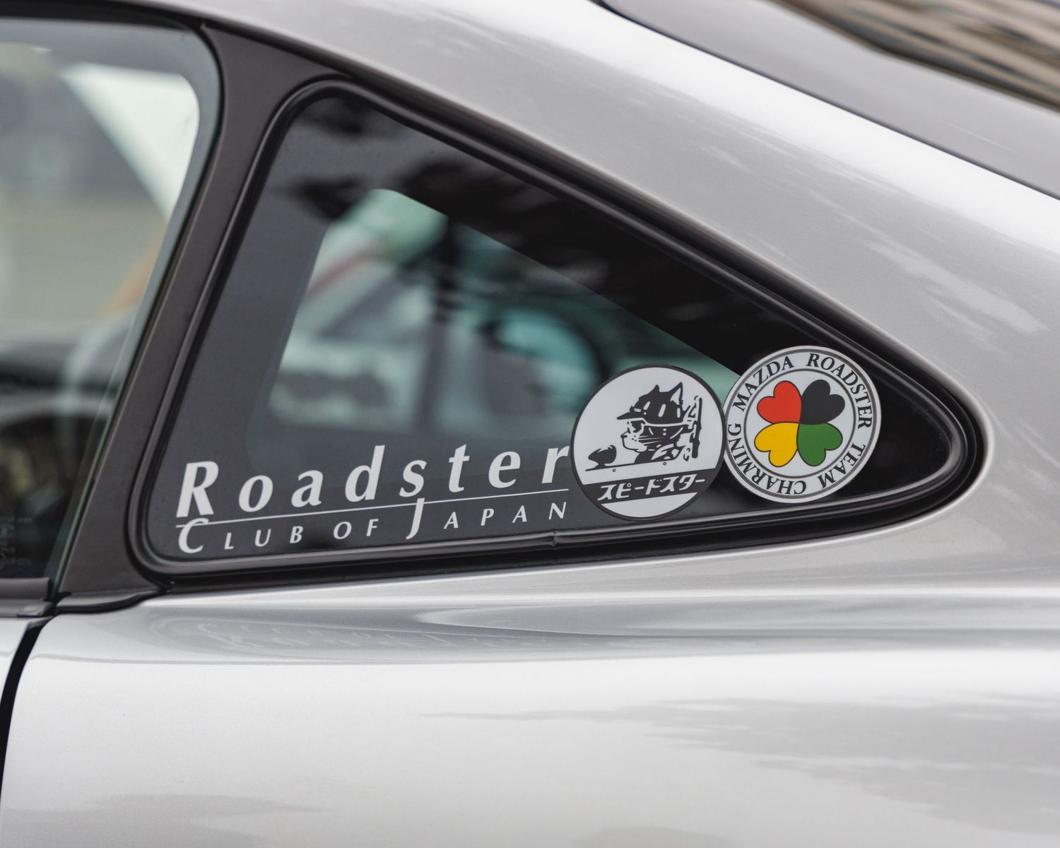 Roadster Club of Japan decal visible on car window glass.