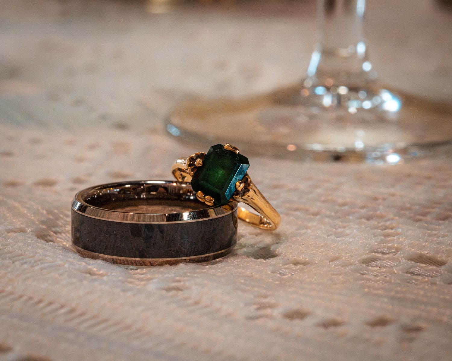 Close-up series of wedding rings and jewelry details on textured fabric.