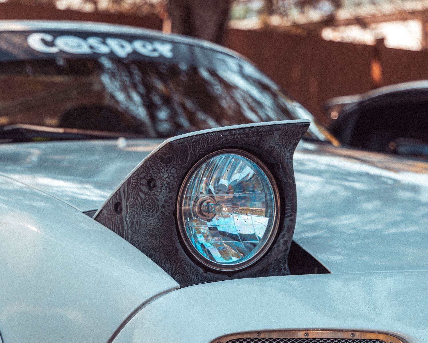 Row of sleek modern headlights on luxury sports cars in a dramatic lighting.