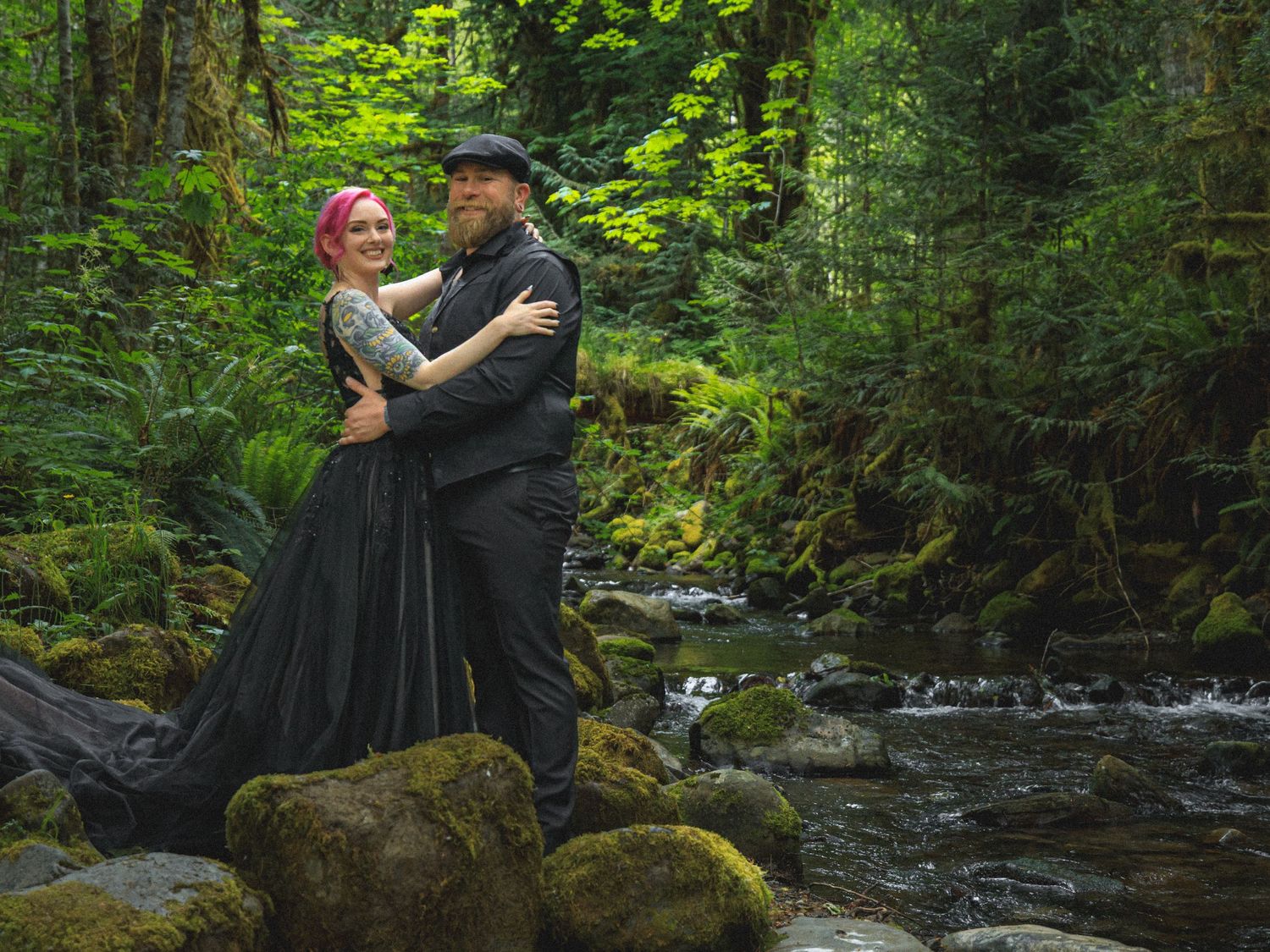 A romantic forest photoshoot near a mossy stream with lush green vegetation.
