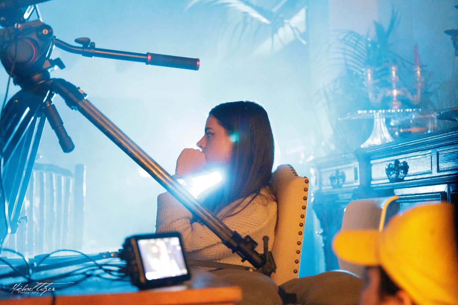 Person working at a desk with professional camera equipment and blue lighting.