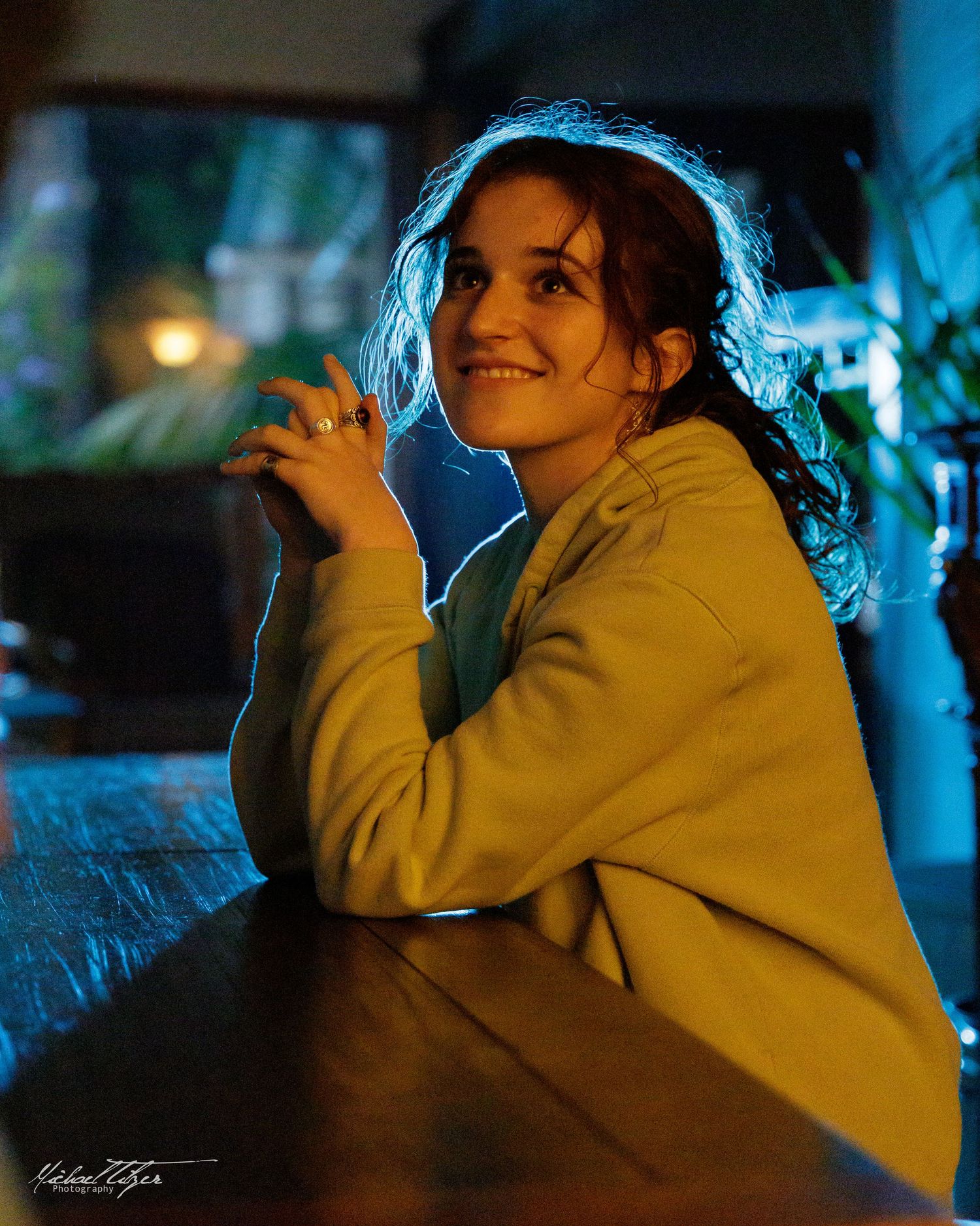 Person in yellow hoodie filmed in moody blue lighting during a night scene.