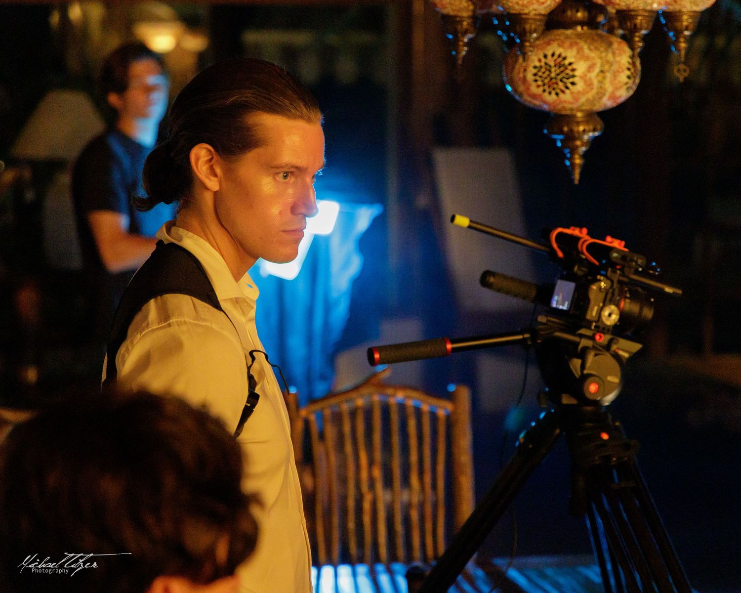 Film crew working on dimly lit set with professional camera equipment.