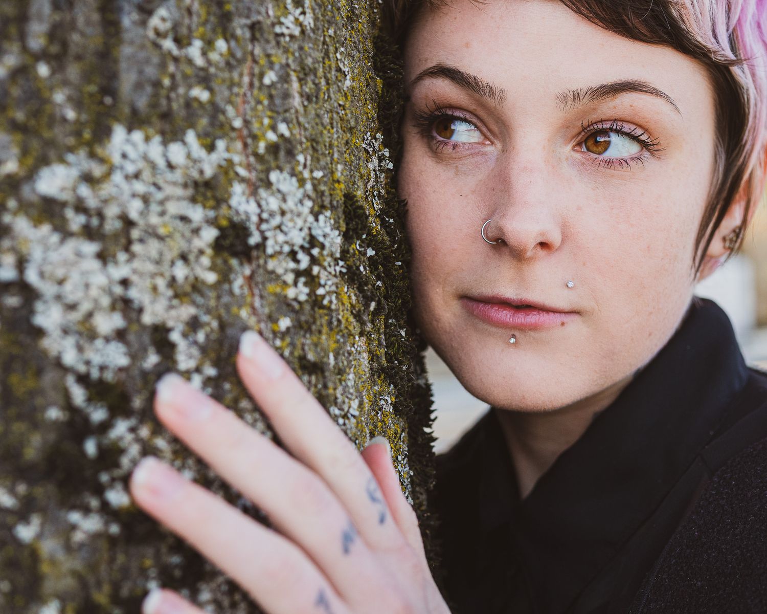Close-up portrait series against a textured tree bark background showing different contemplative expressions.