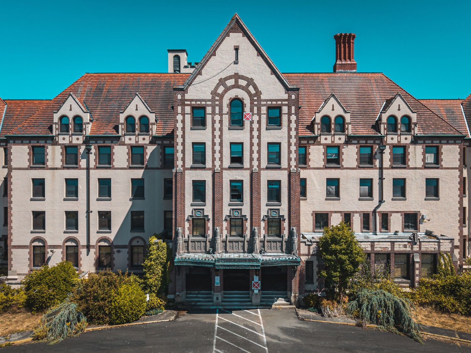 Historic brick building facade with Victorian architectural details and repeating windows stretches across panoramic view.