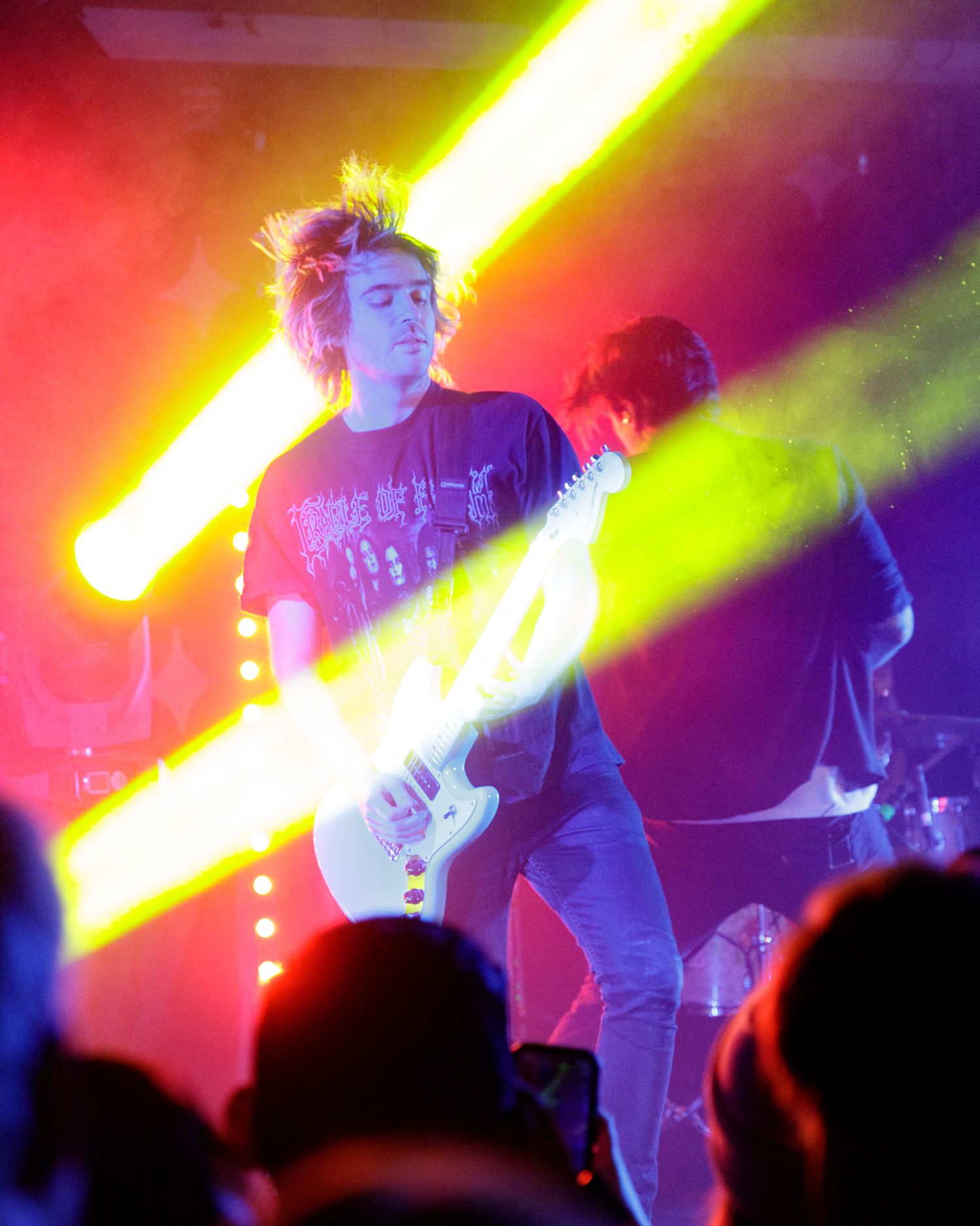Rock concert scene with dramatic yellow and red lighting effects illuminating the stage.