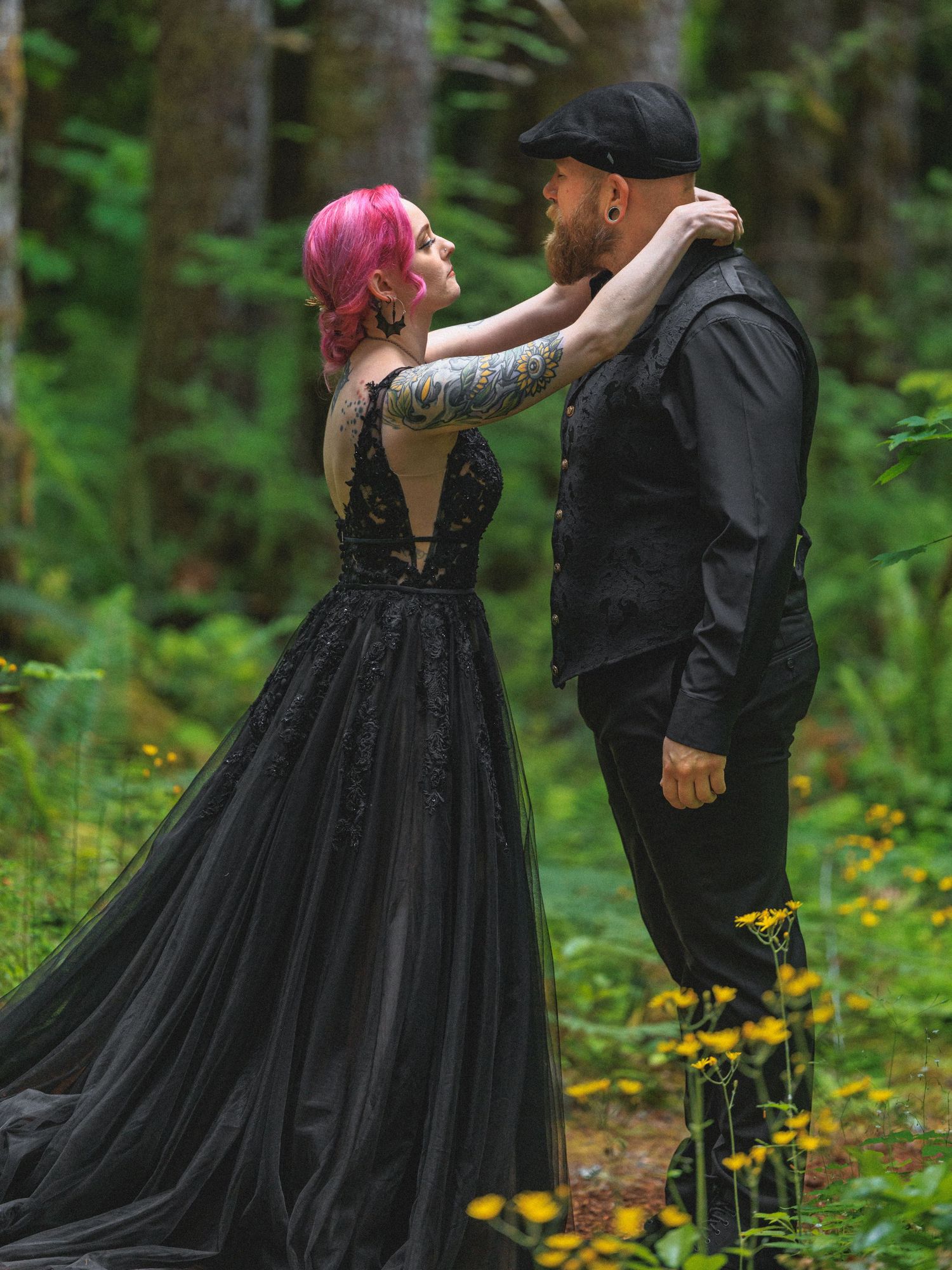 A couple dances in a forest clearing surrounded by yellow wildflowers.