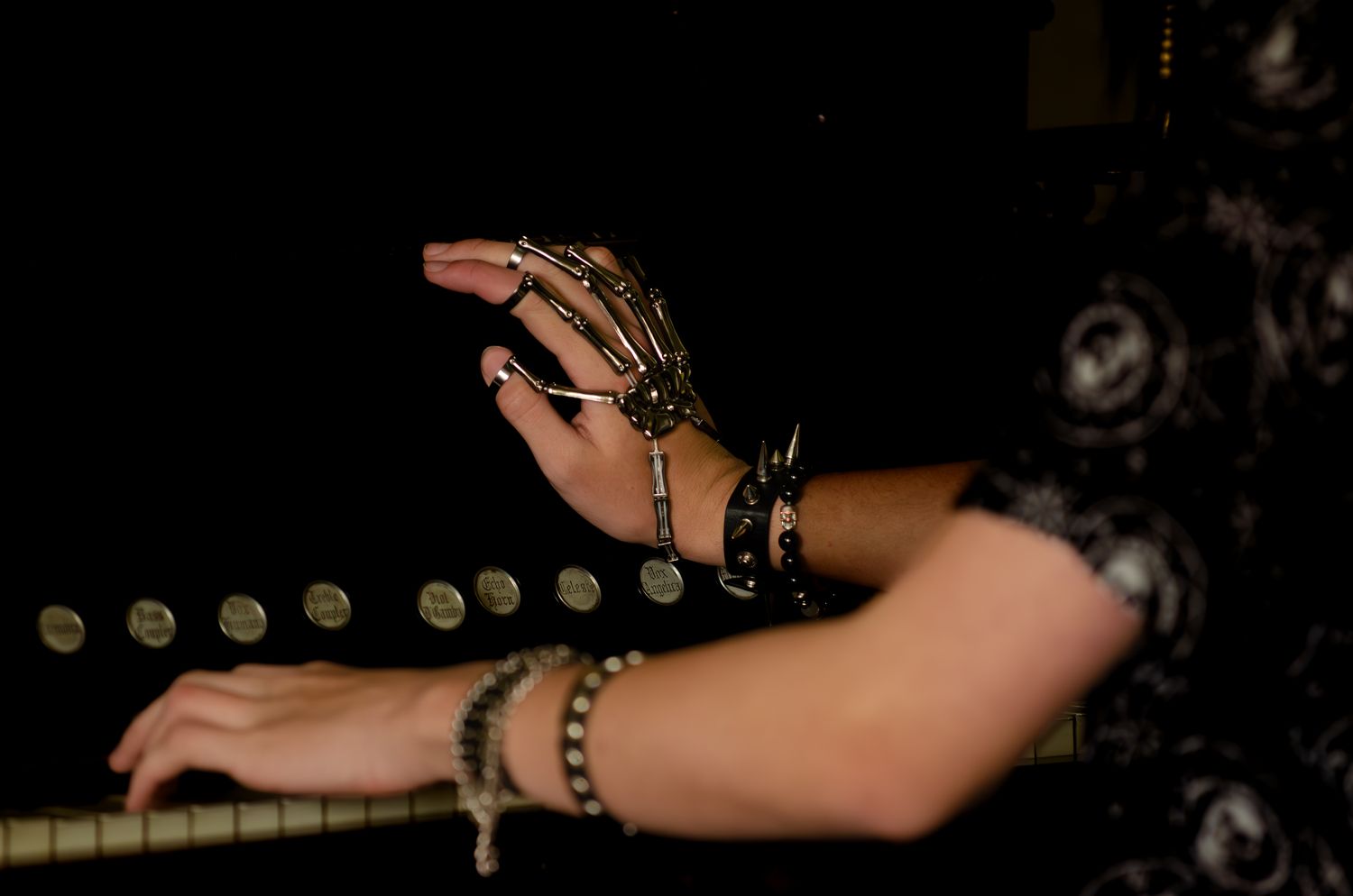 Hands adorned with multiple rings and bracelets extended in artistic pose.