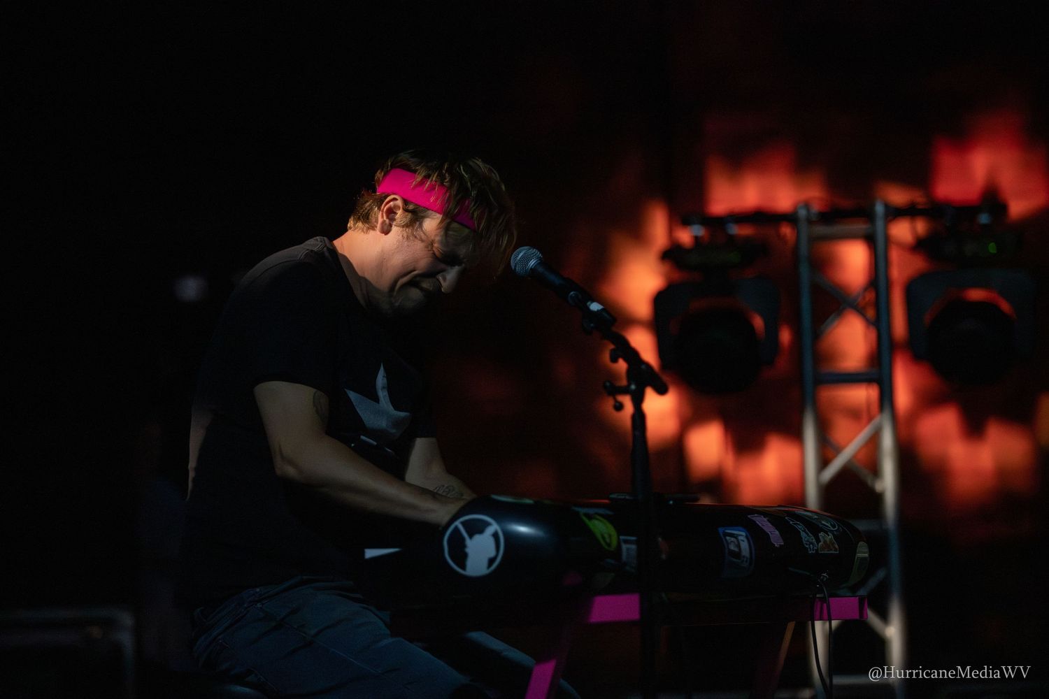 A collection of dimly lit concert photos with dramatic red lighting shows performers on stage during a live music event.