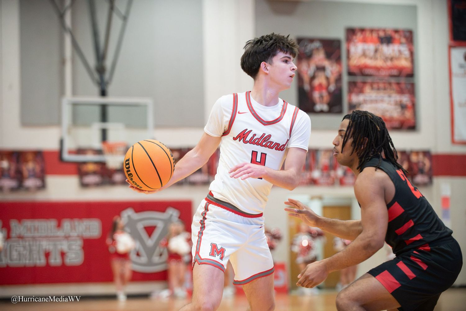 Basketball players compete for possession during an intense game in a high school gymnasium.