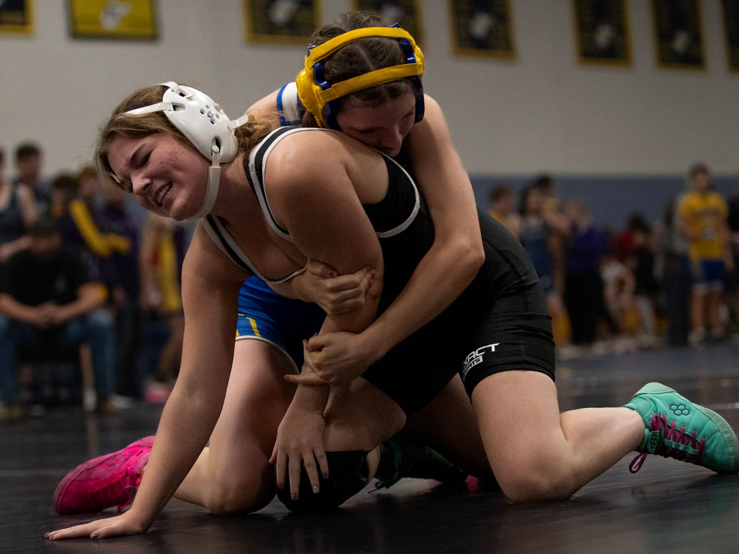 High school wrestlers grapple during a competitive match on the mat.