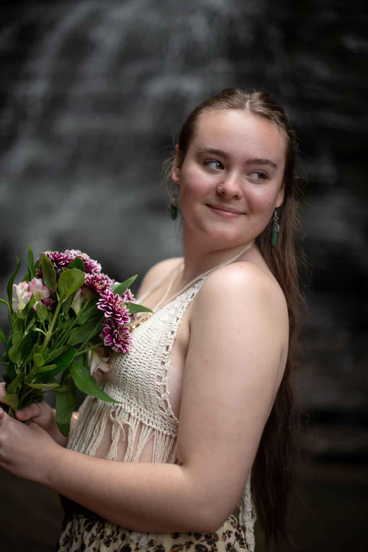 A gentle portrait in soft lighting with a white crochet top and flowers.
