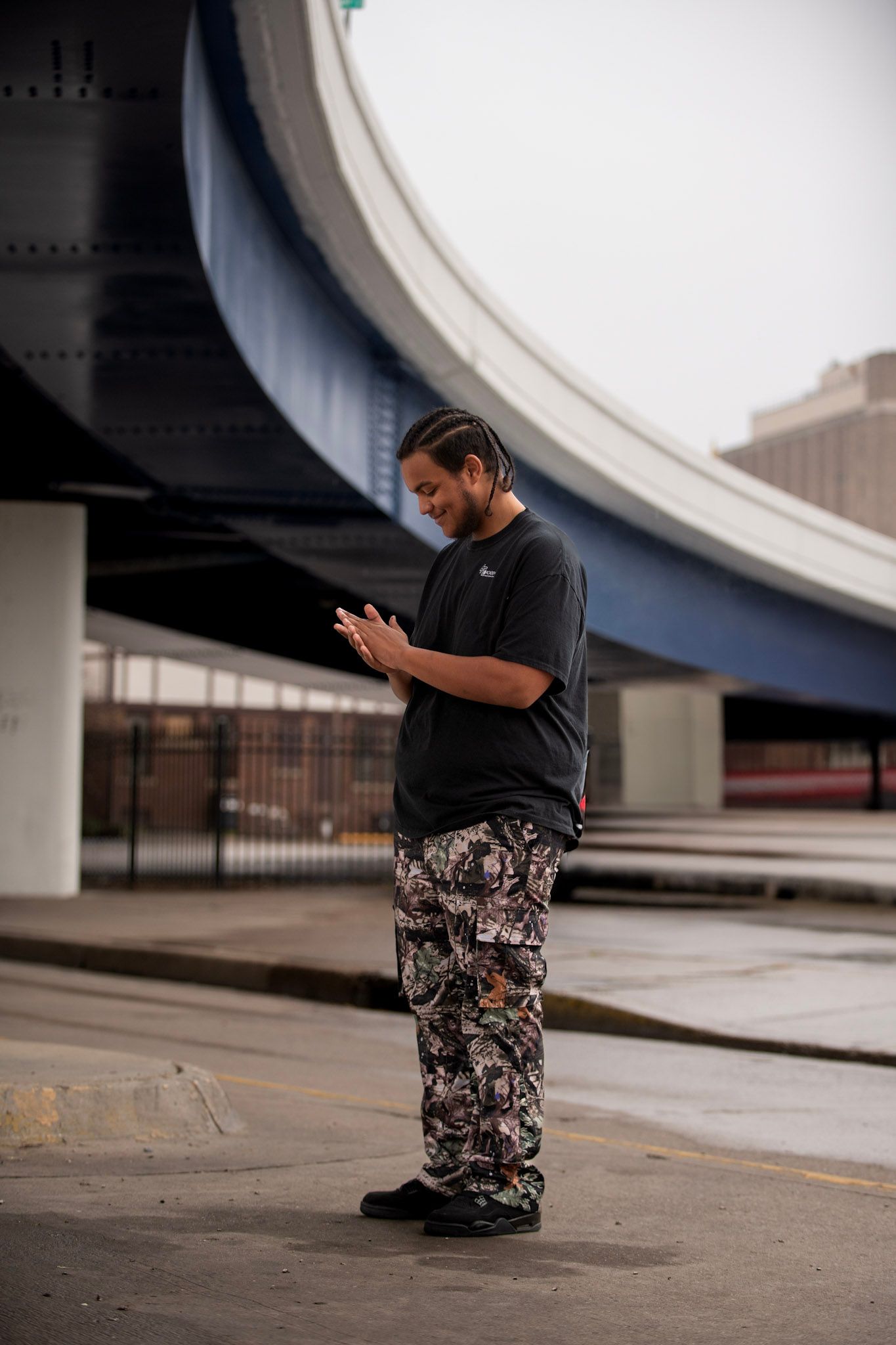 Person in dark clothing photographed from low angle against curved architectural structure.