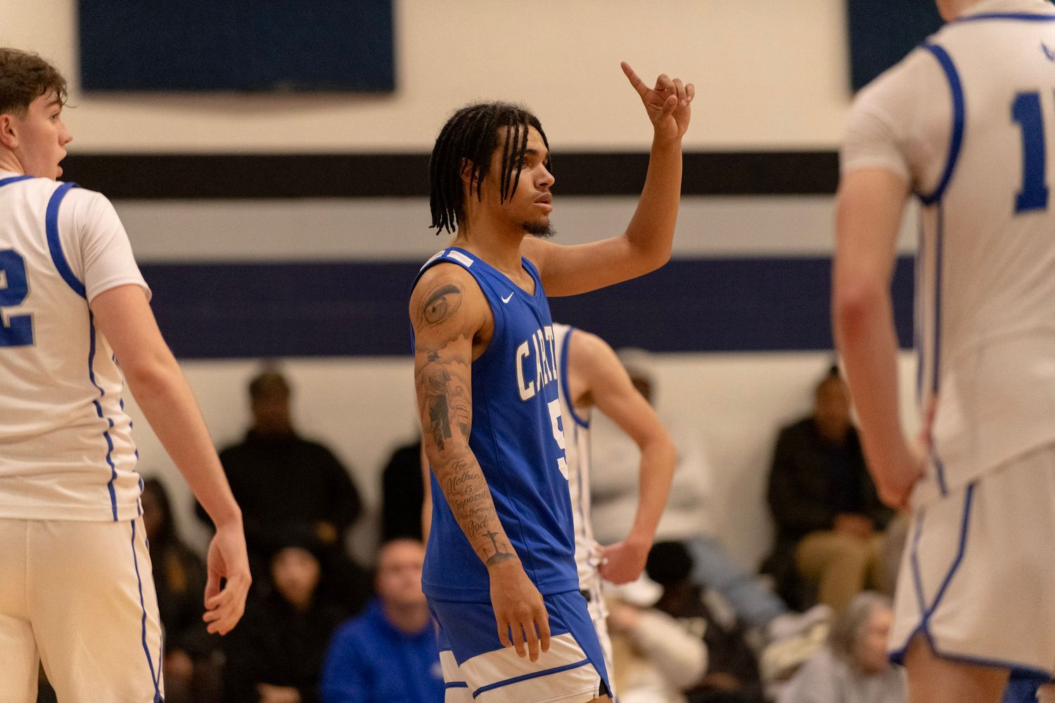 Basketball player in blue jersey gestures during competitive game.