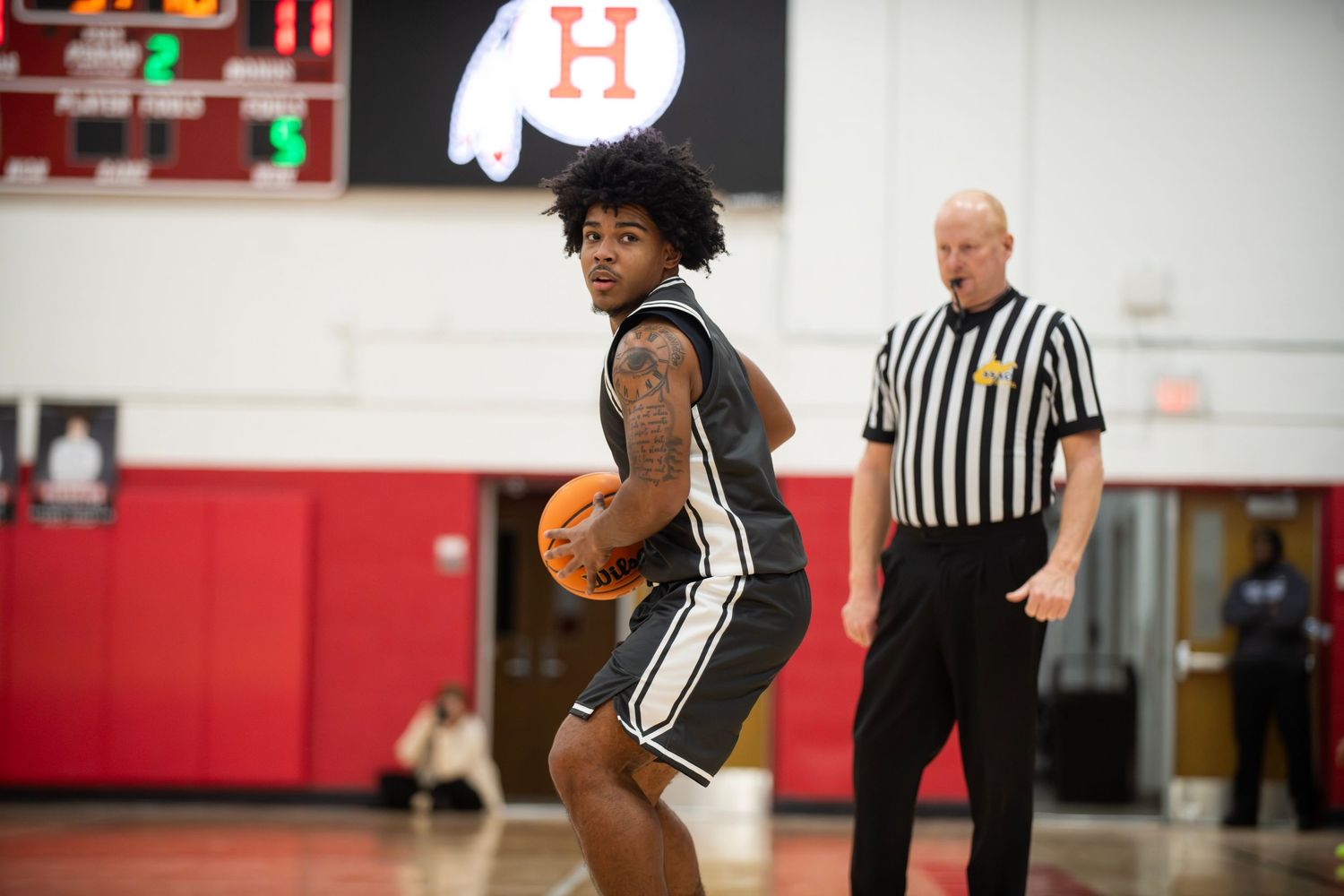 Basketball players and referees gather on a court during an intense game moment.