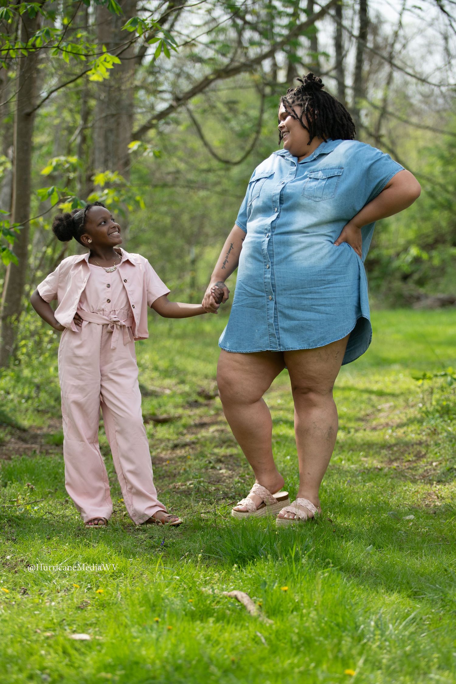 Playful outdoor photoshoot showing casual clothing and pink shoes against green grass.