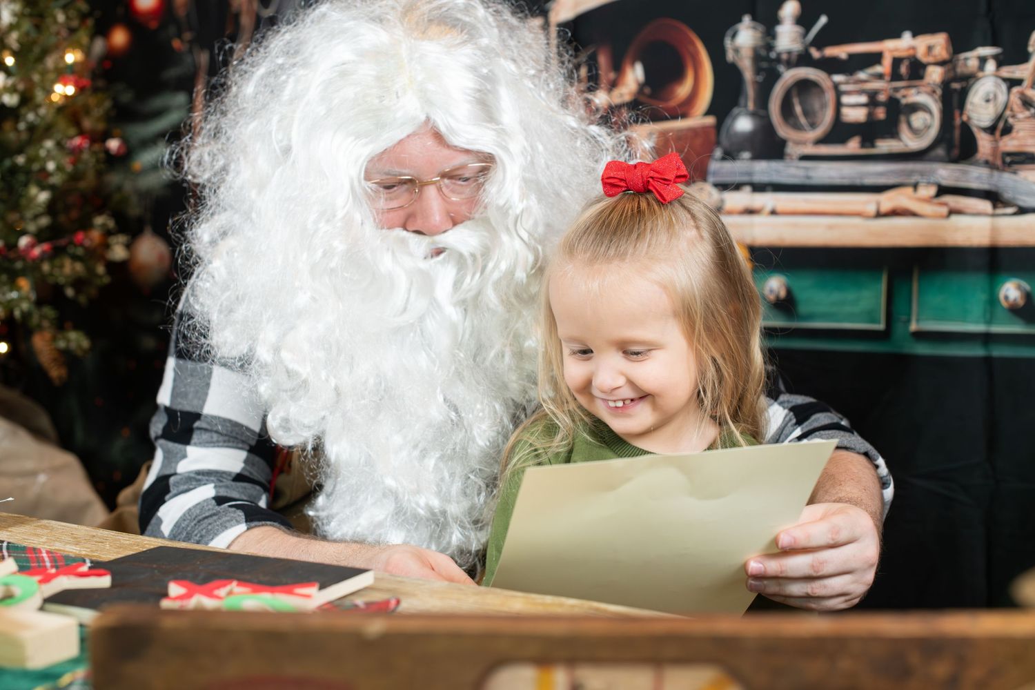 A child smiles with joy while meeting Santa Claus during a festive holiday gathering.