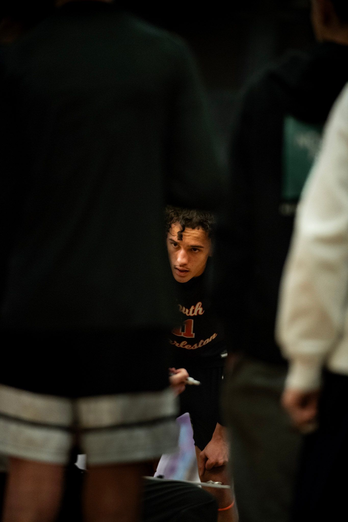 Low light portrait of an athlete in a dark gymnasium setting.