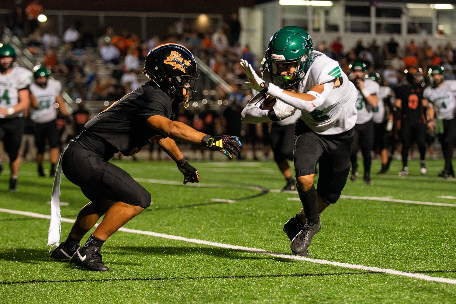 Football players scramble for possession of the ball during an intense ground play near the sideline.