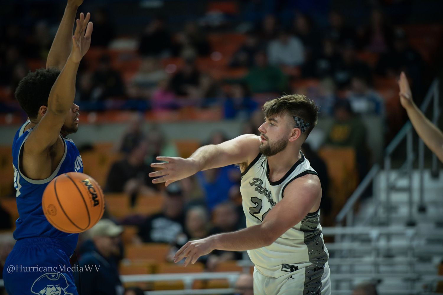 Basketball player makes passing motion during intense game action.