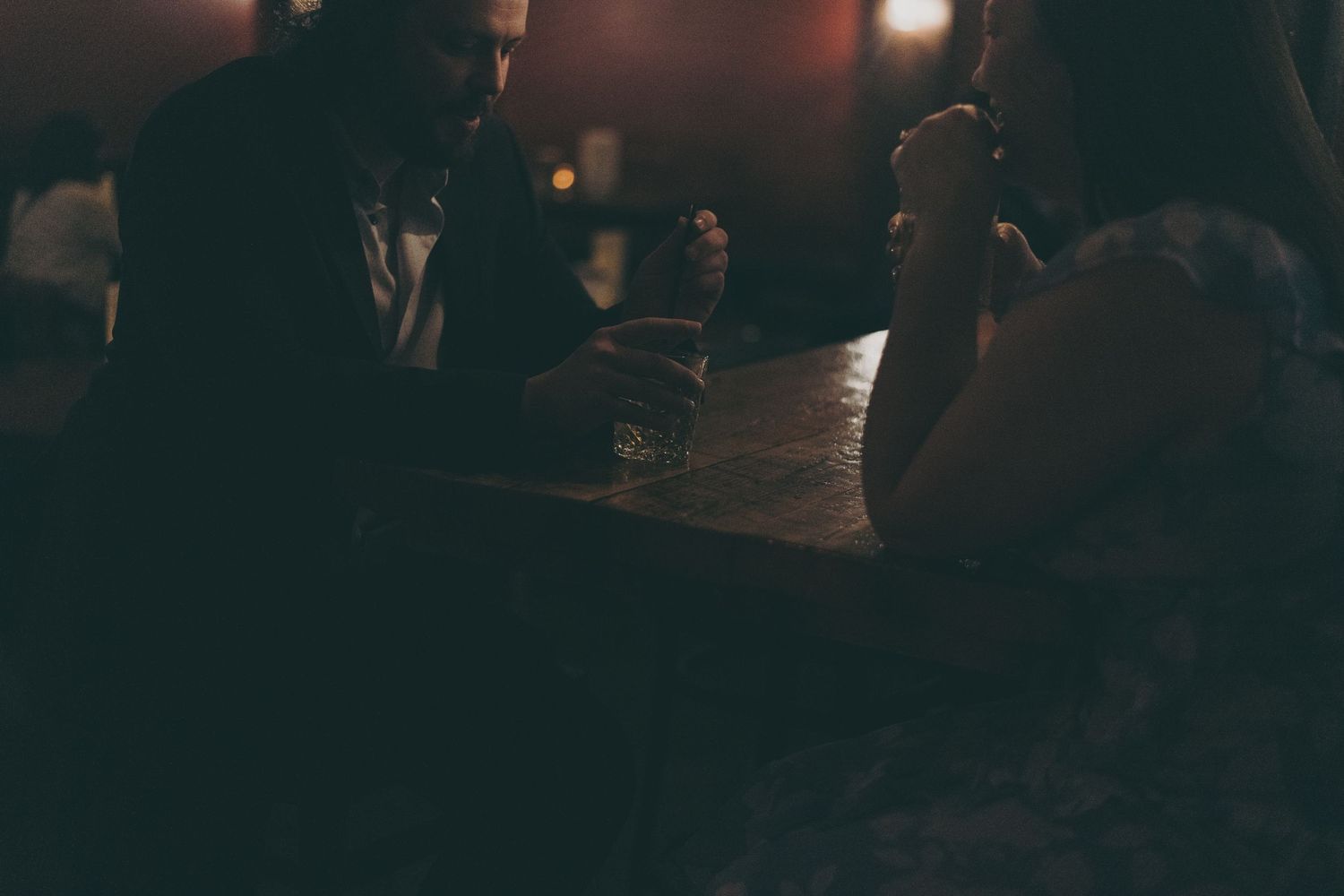 Dark atmospheric night scene with silhouettes in a dimly lit setting.