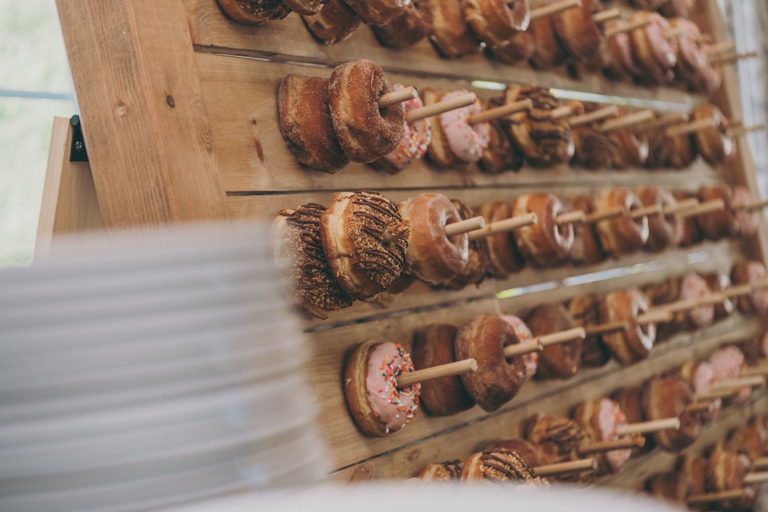 Close-up of rustic wooden wall display with multiple rows of hanging vintage door knobs.