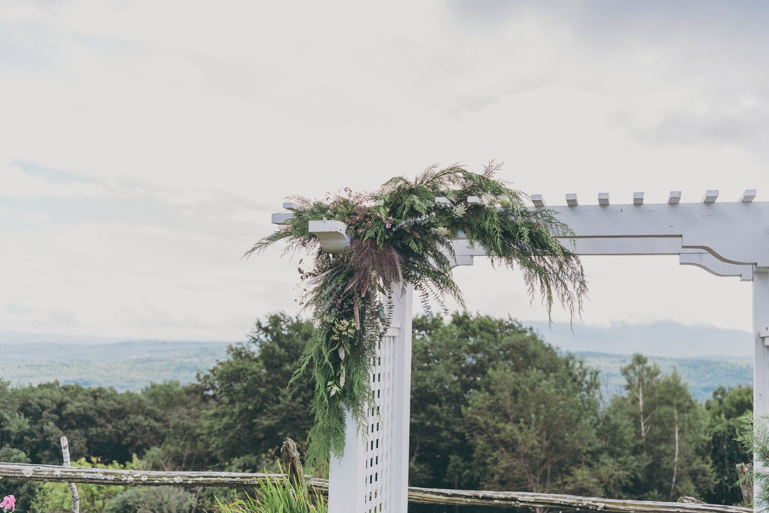 White pergola walkway leads through lush tropical gardens at a Hawaiian resort property.