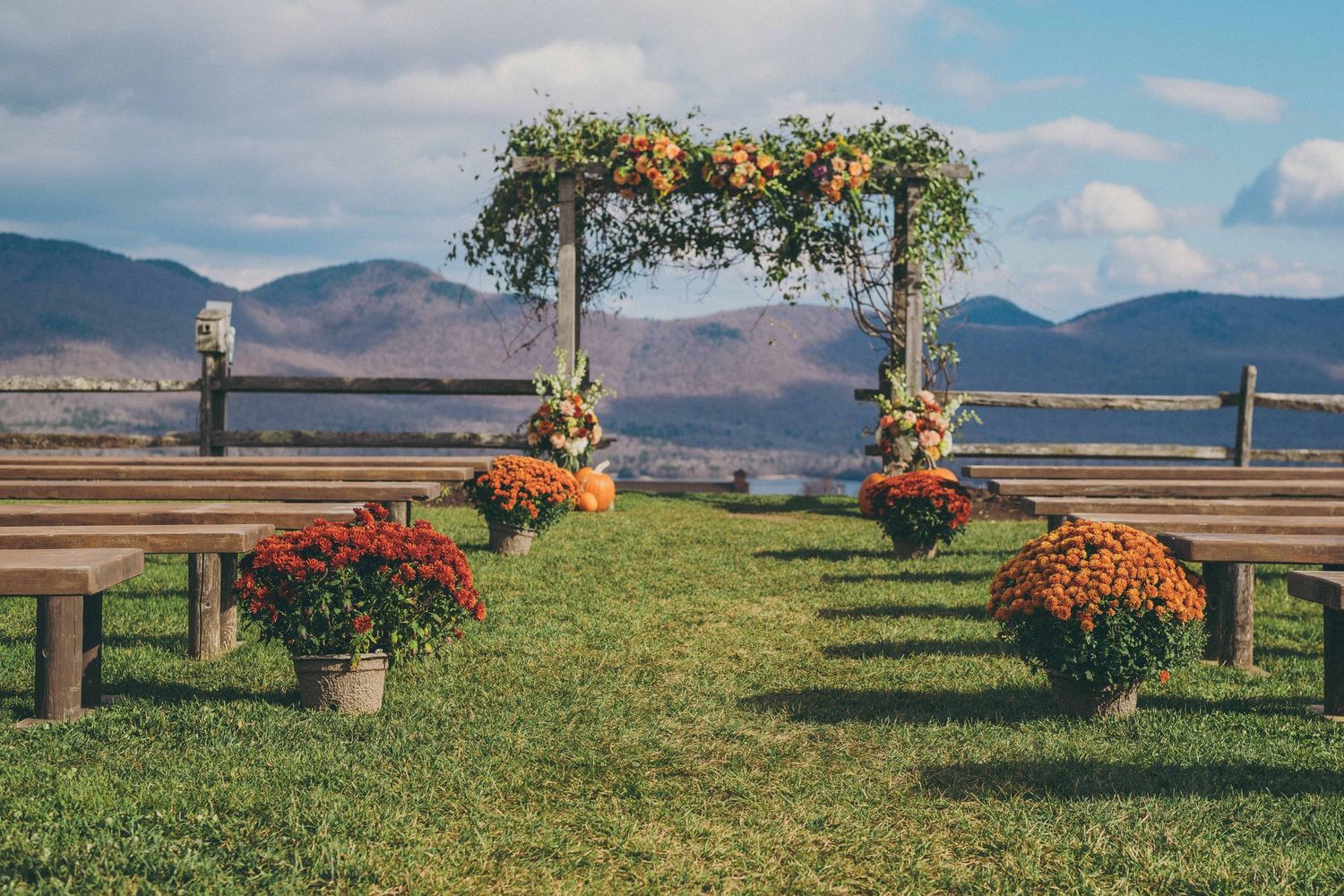 A panoramic photo collage showing lush green lawns, colorful fall flowers, and distant mountain views near a waterfront setting.