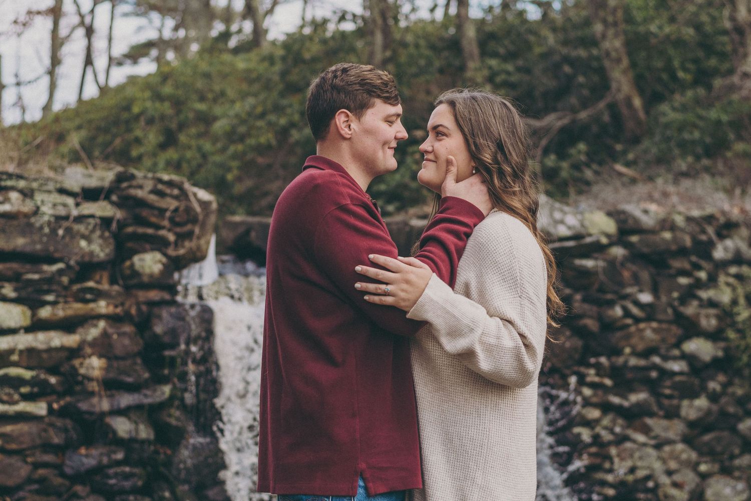 Series of romantic poses against a stone wall backdrop in autumn.