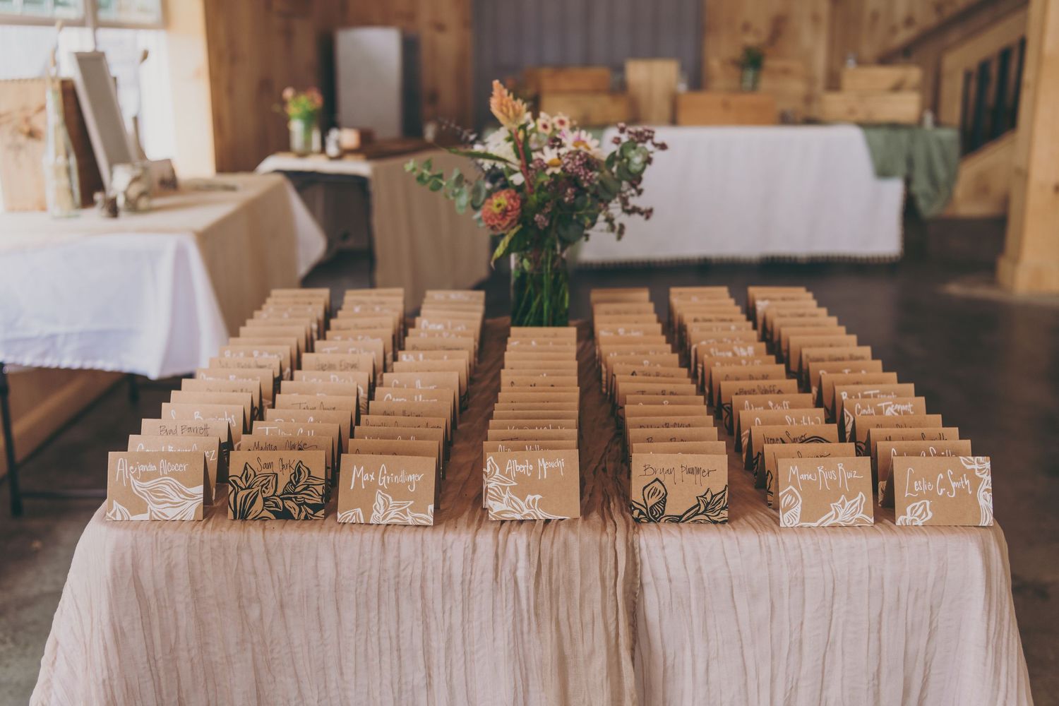 Rustic wooden place card holders lined up on tables at an elegant wedding reception.