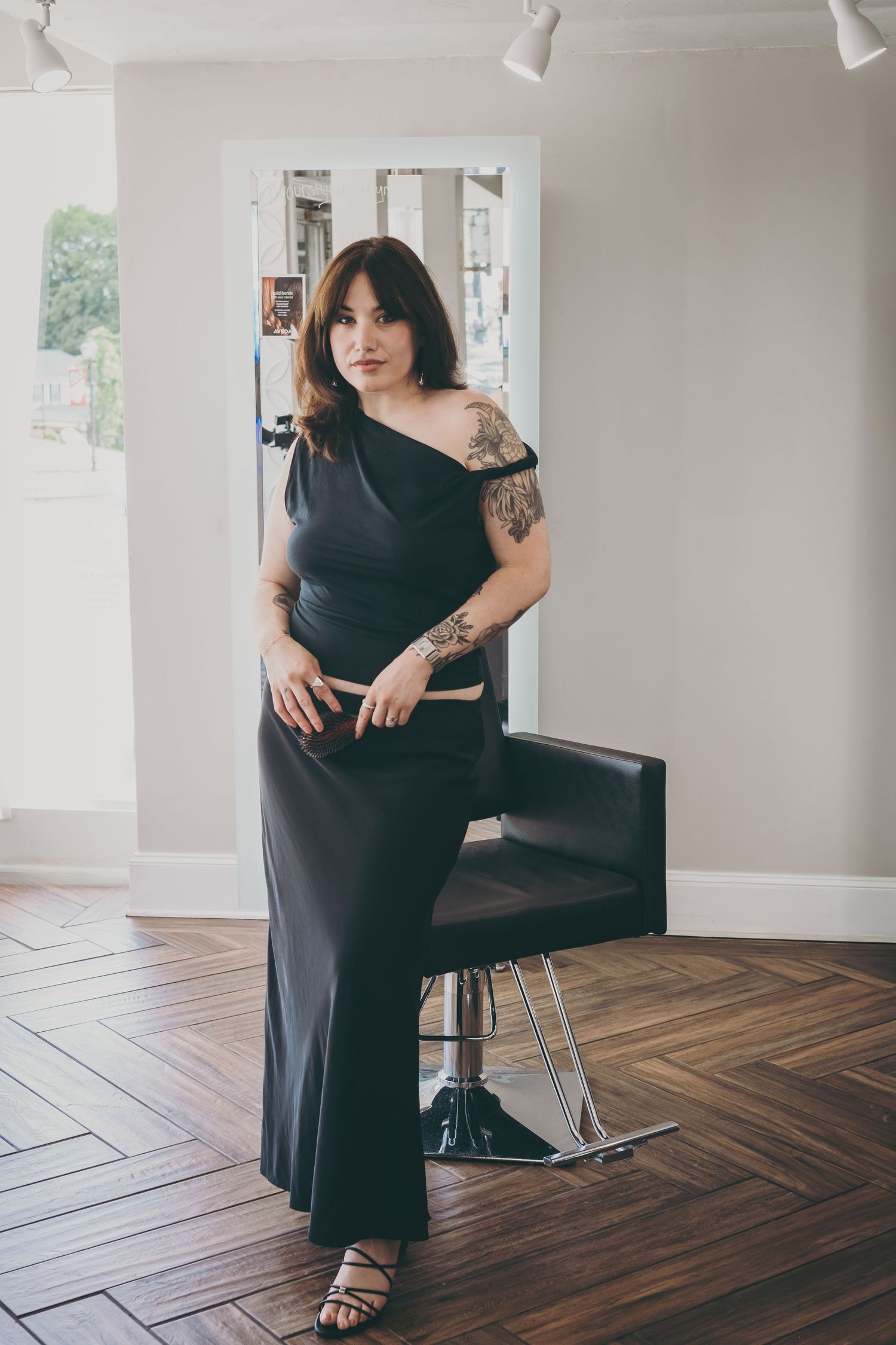 Relaxed studio portraits showcasing casual black outfit on hardwood floors.