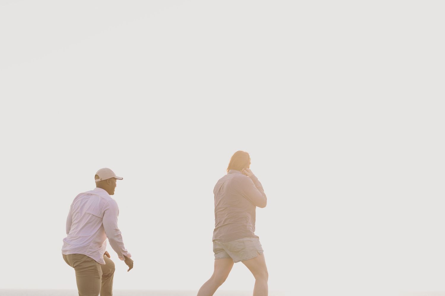 Three people dressed walk through a misty scene landscape at sunrise.