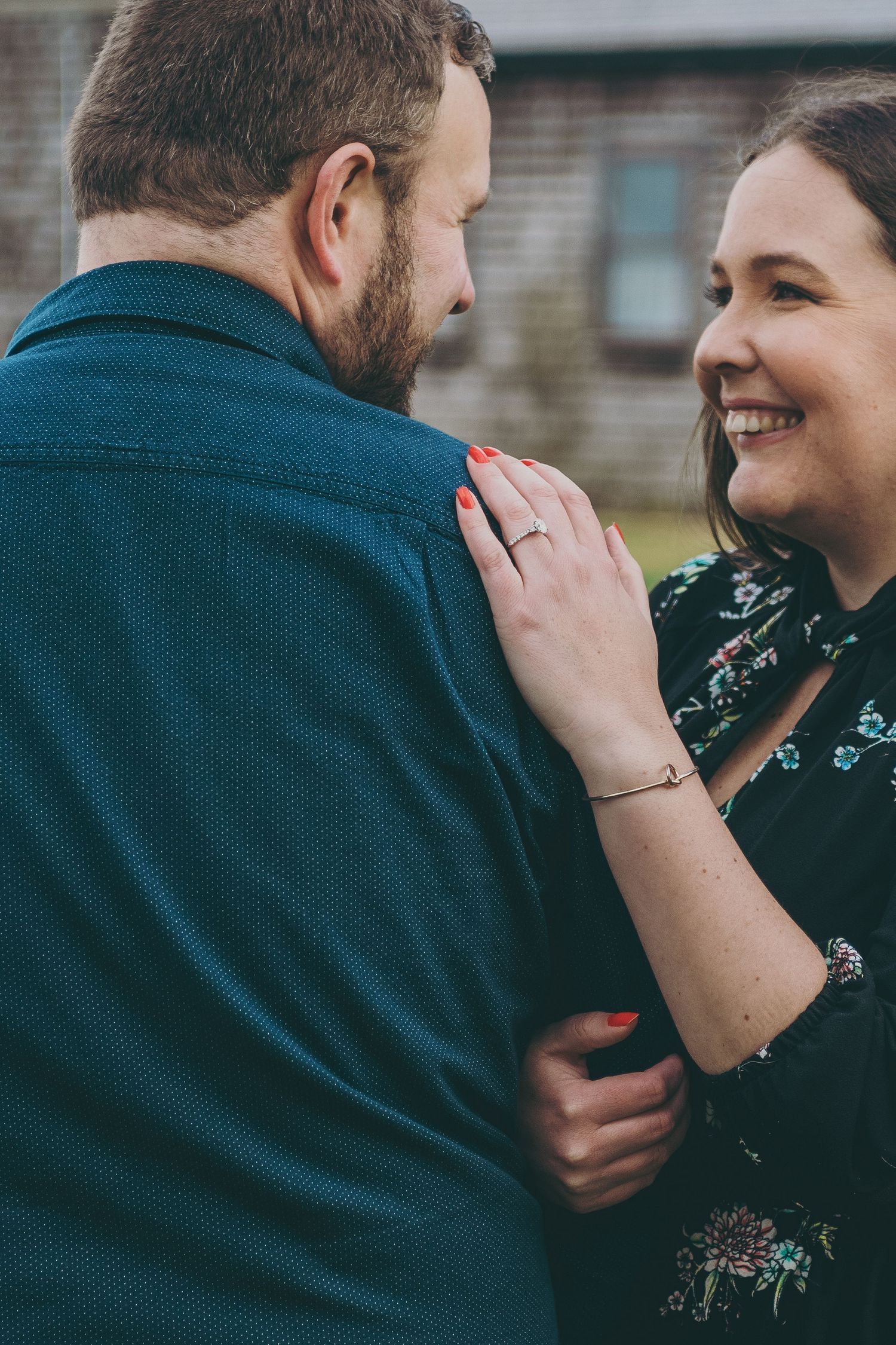 A couple shares an intimate moment while wearing dark blue and floral clothing.