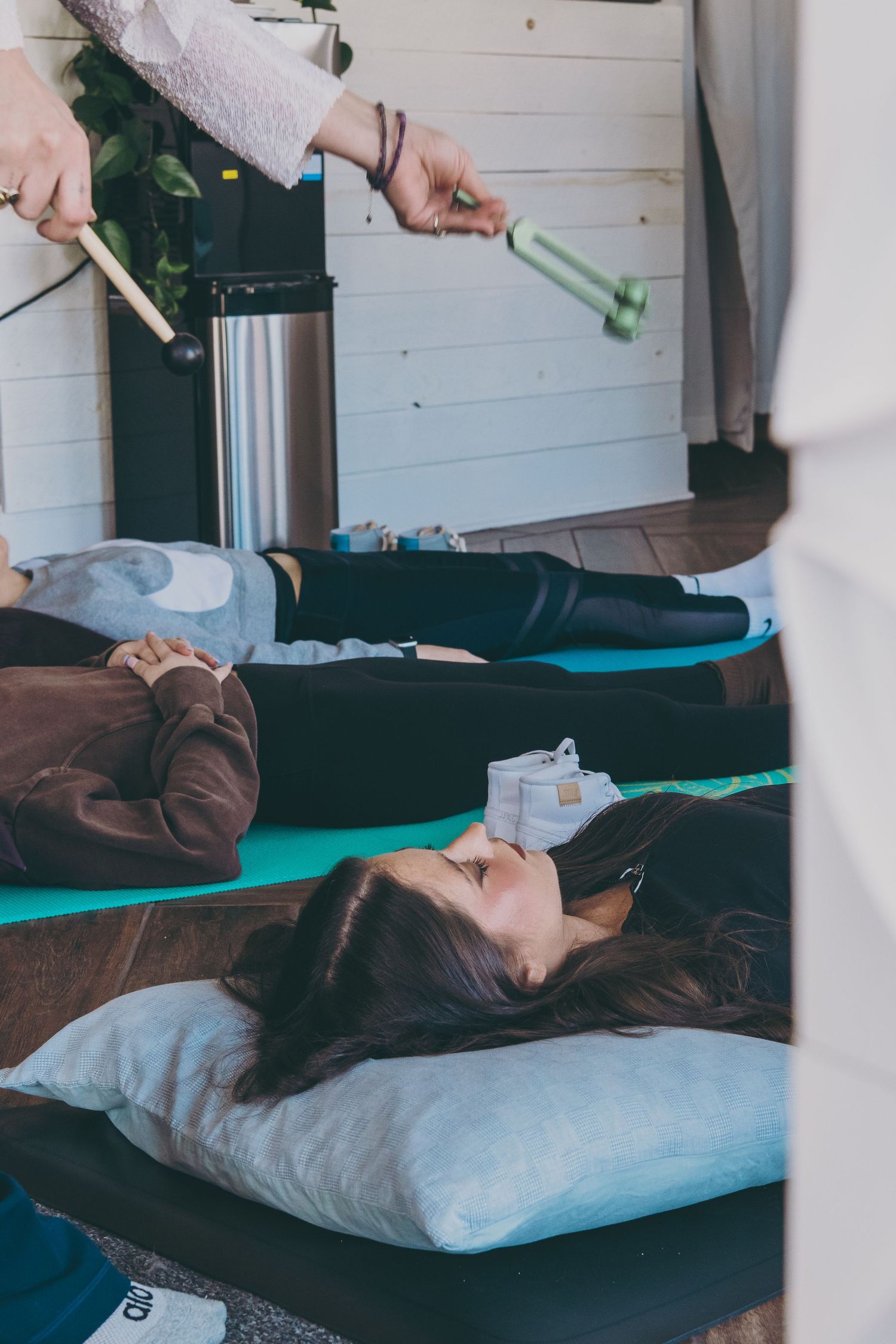 Person receiving reiki or energy healing treatment on massage table in wellness studio.