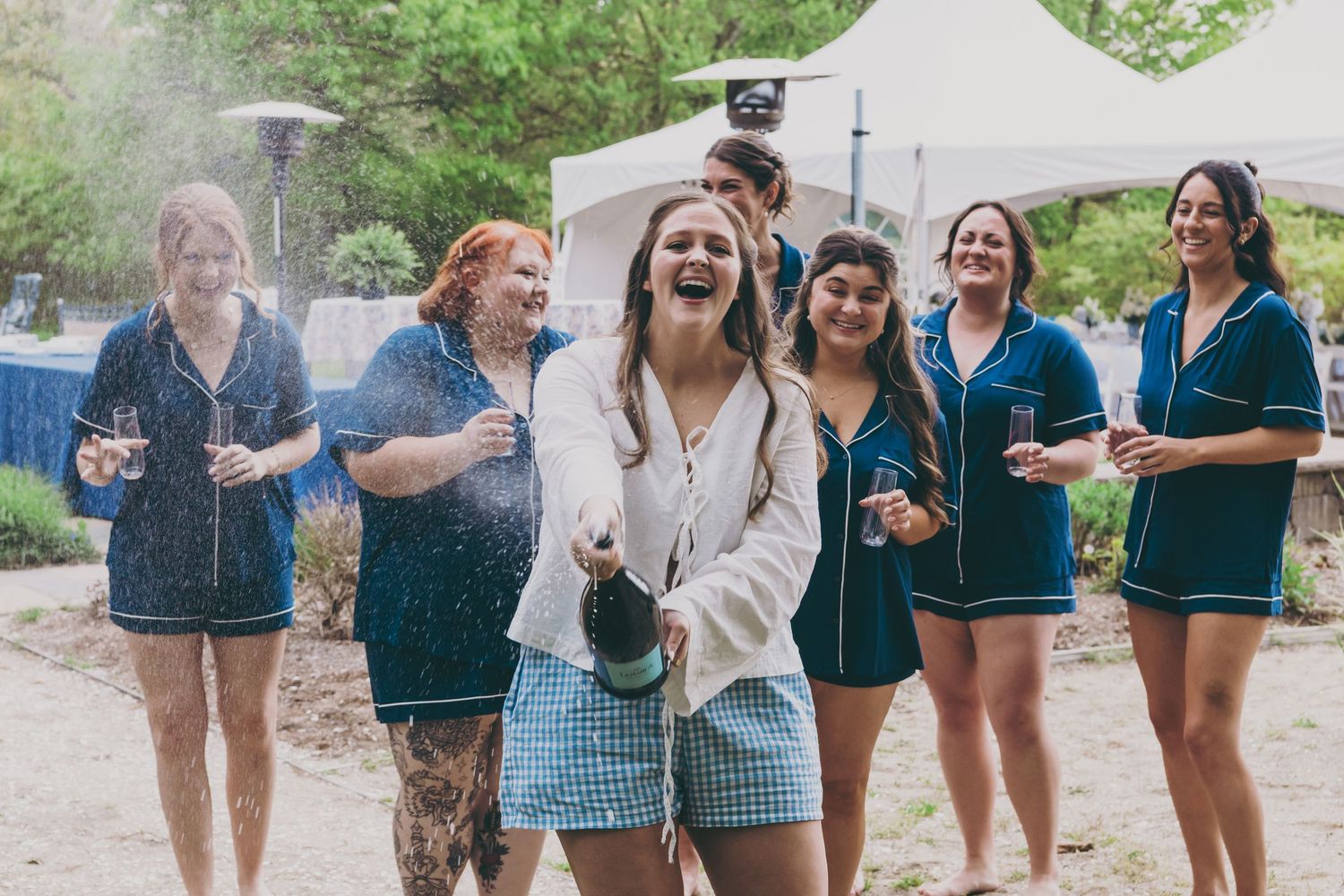 A group celebrating outdoors with champagne and laughter.